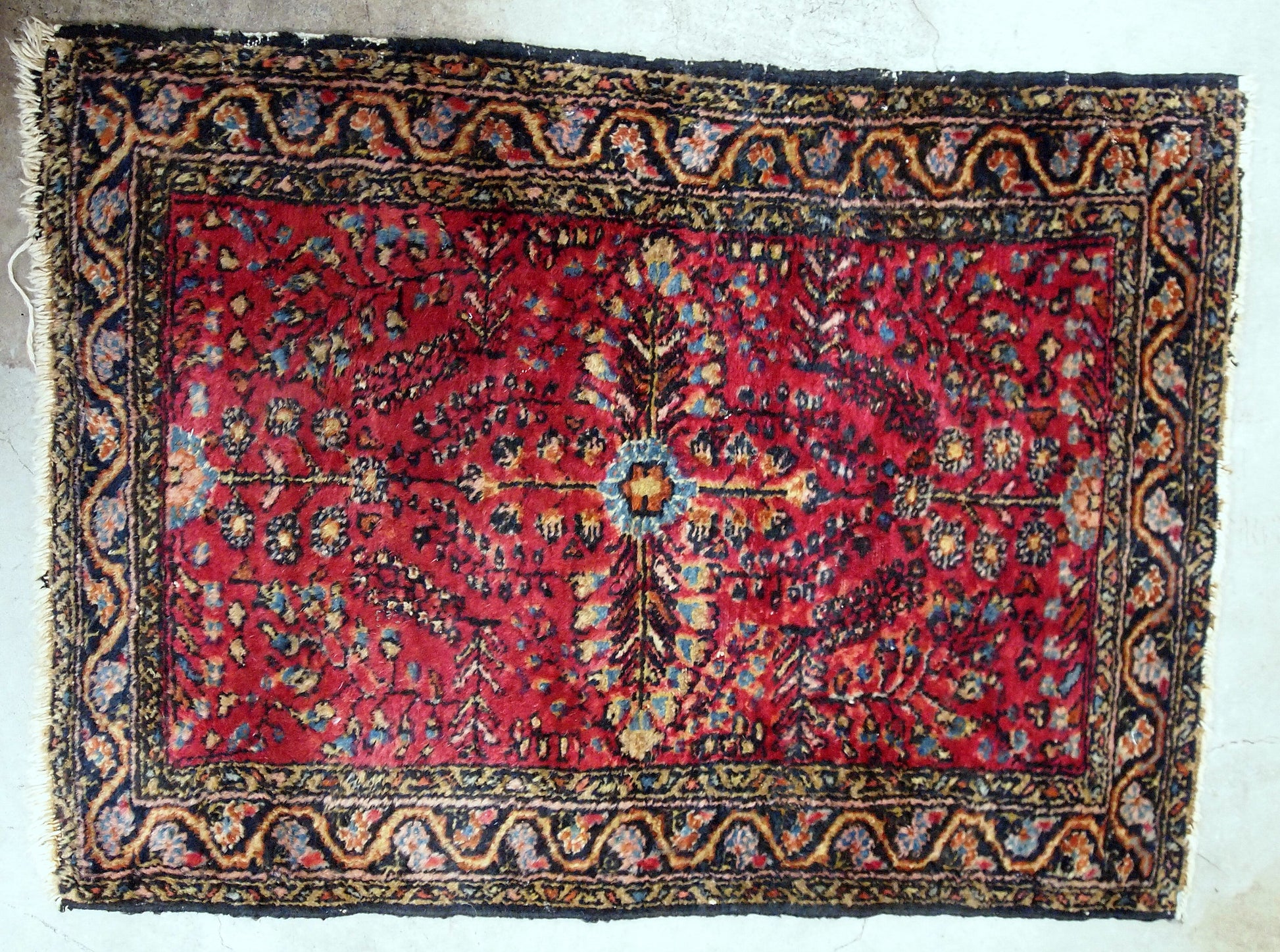 Antique handmade Persian Sarouk rug in red color with classic design. It is from the beginning of 20th century in original good condition.