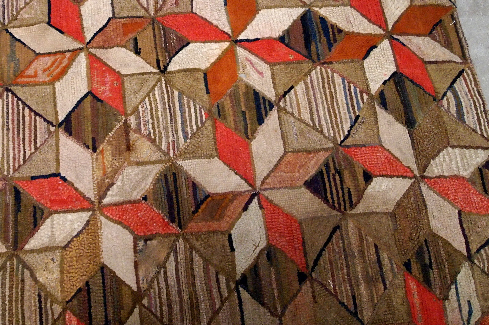 Antique handmade geometric American Hooked rug in brown, red, beige and olive shades. The rug has several holes, they has been restored, it is in good condition now.