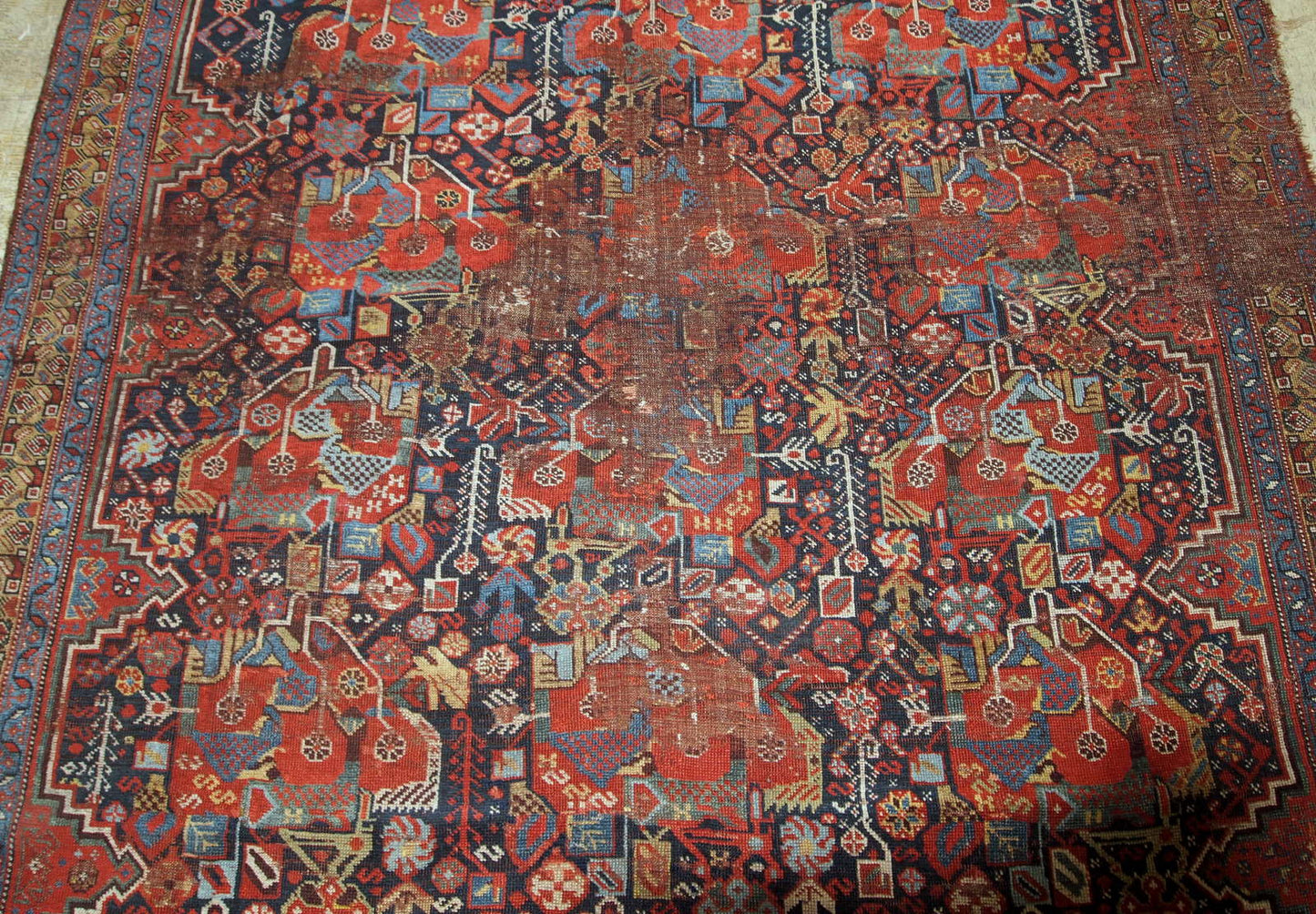 Antique handmade collectible Khamseh rug from the mid-18th century. It is in bright natural colours and in distressed condition.