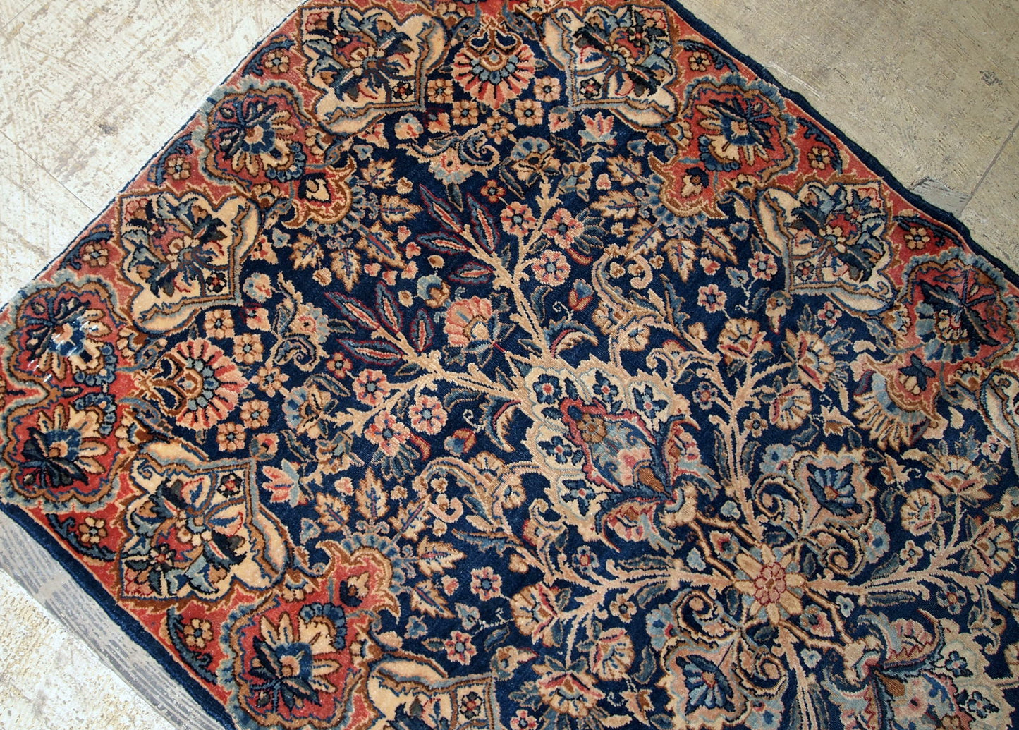 Antique handmade Kerman rug in navy blue shade with classic design. The rug is in original condition, has some low pile.