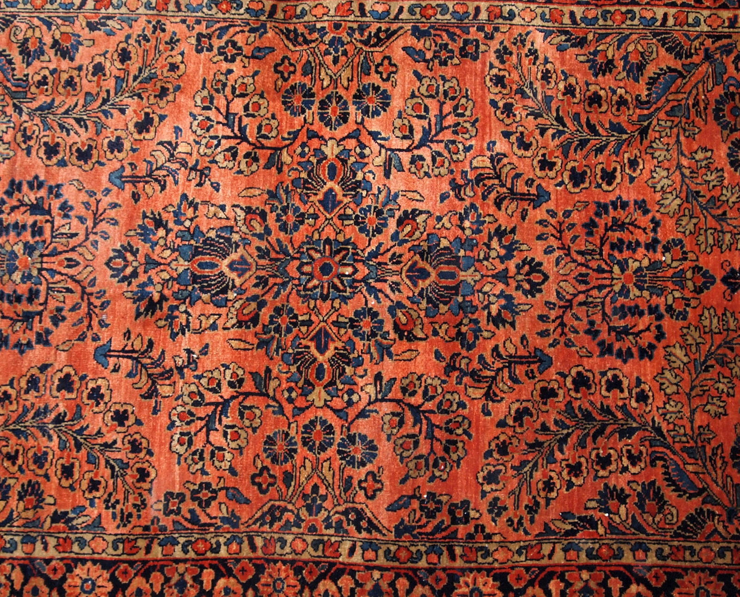Antique Sarouk rug in red shade with classic floral design. The rug is from the beginning of 20th century in original good condition.