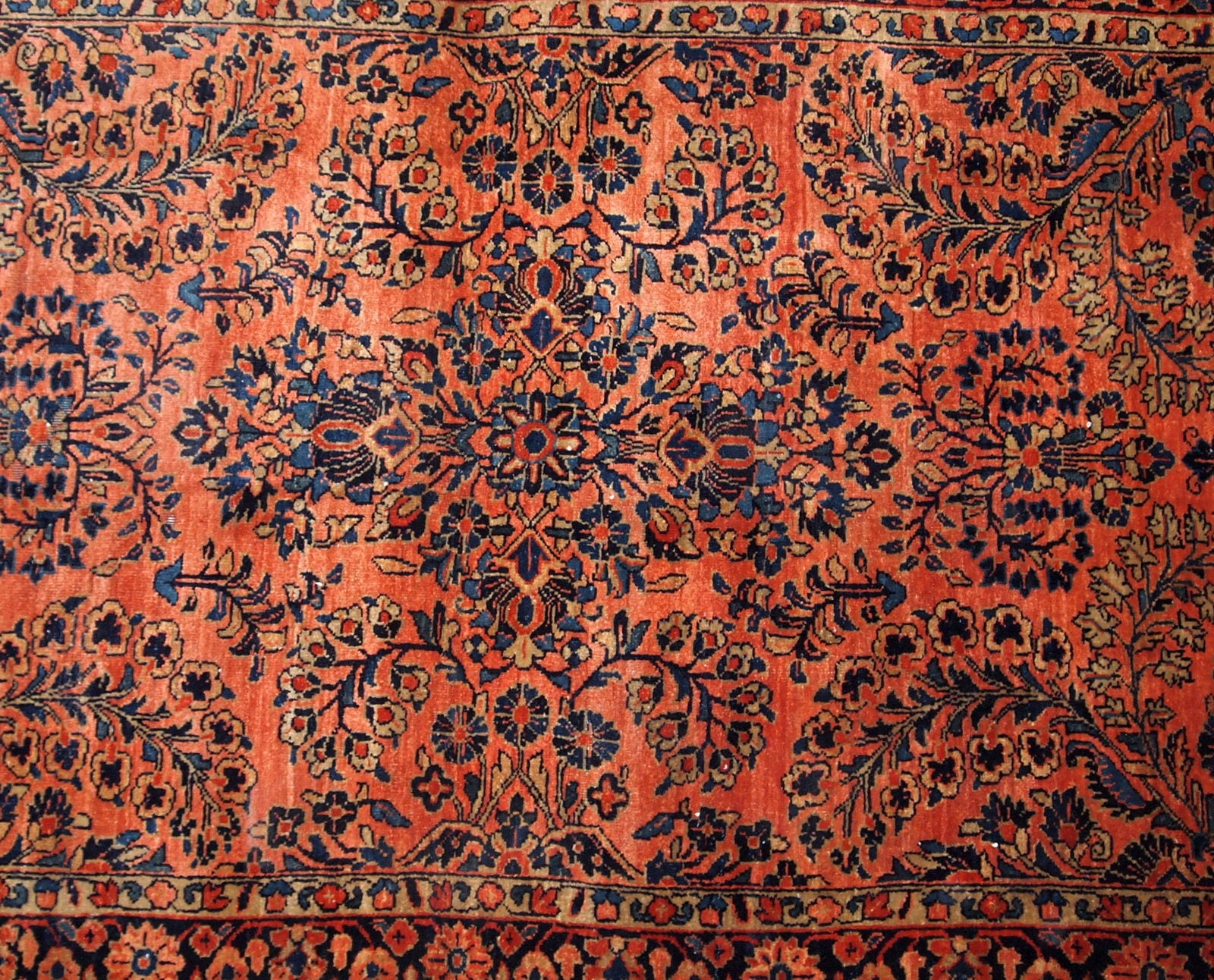 Antique Sarouk rug in red shade with classic floral design. The rug is from the beginning of 20th century in original good condition.