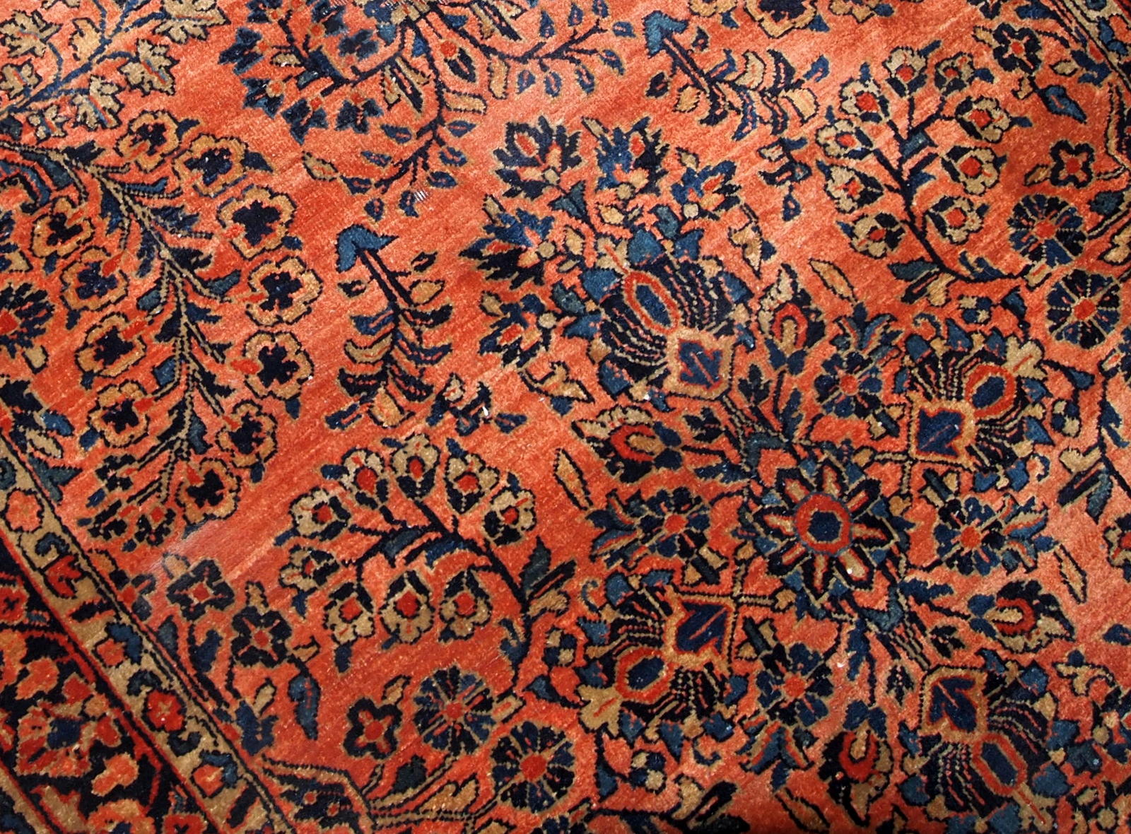 Antique Sarouk rug in red shade with classic floral design. The rug is from the beginning of 20th century in original good condition.