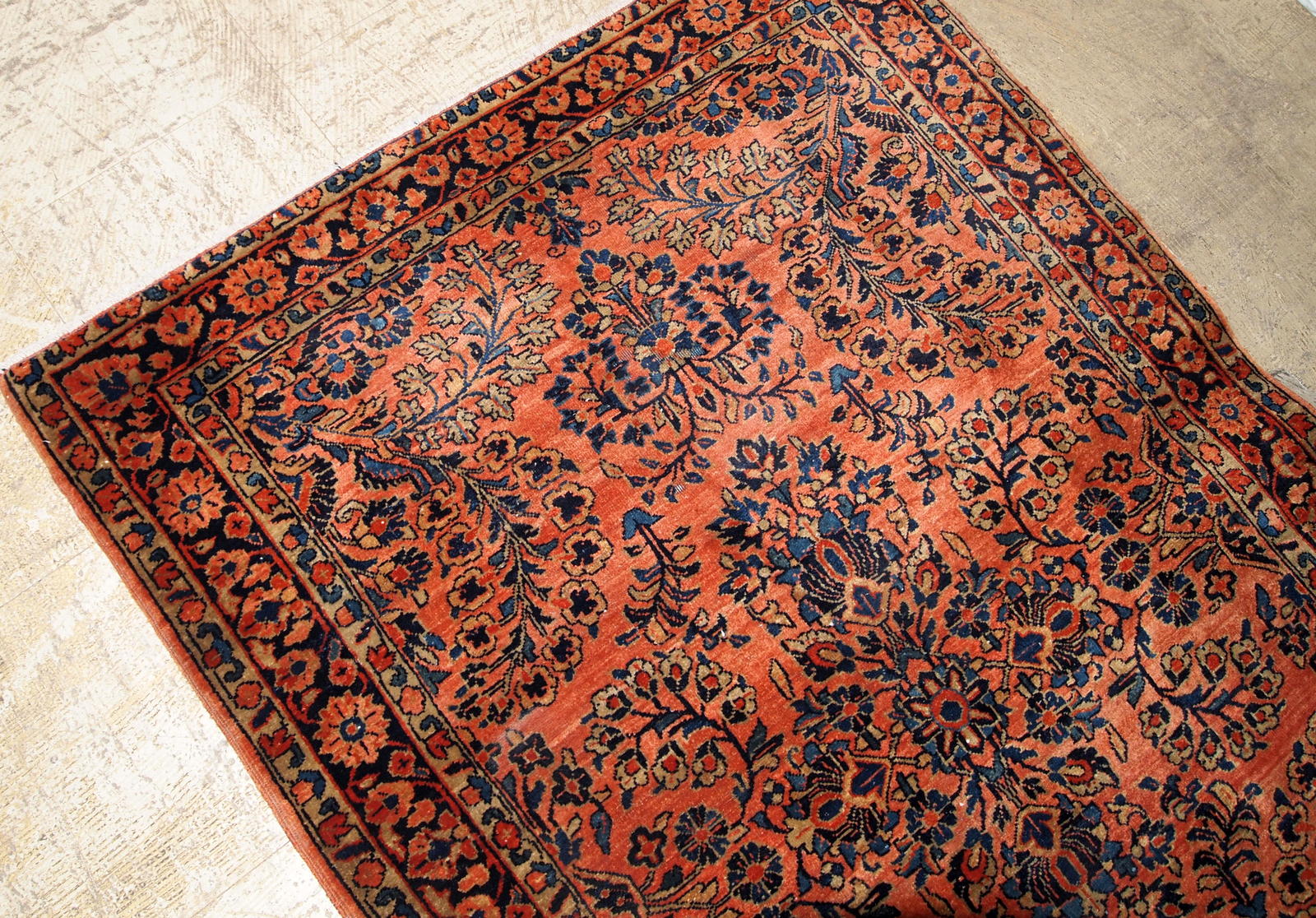 Antique Sarouk rug in red shade with classic floral design. The rug is from the beginning of 20th century in original good condition.