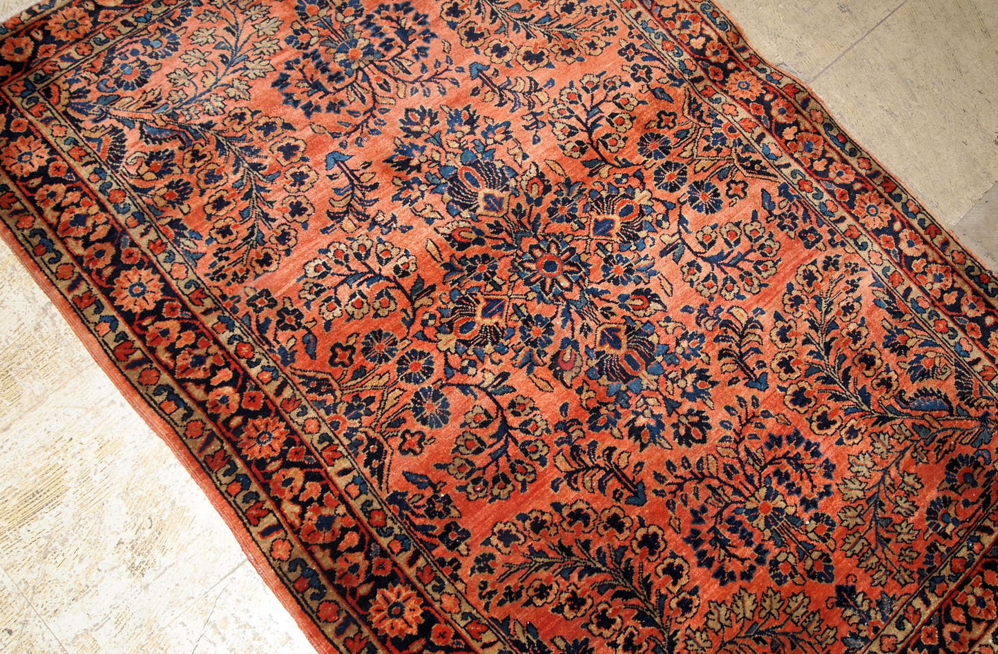 Antique Sarouk rug in red shade with classic floral design. The rug is from the beginning of 20th century in original good condition.