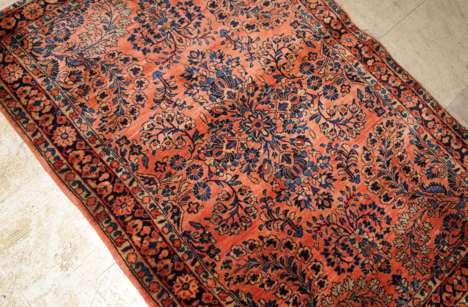 Antique Sarouk rug in red shade with classic floral design. The rug is from the beginning of 20th century in original good condition.