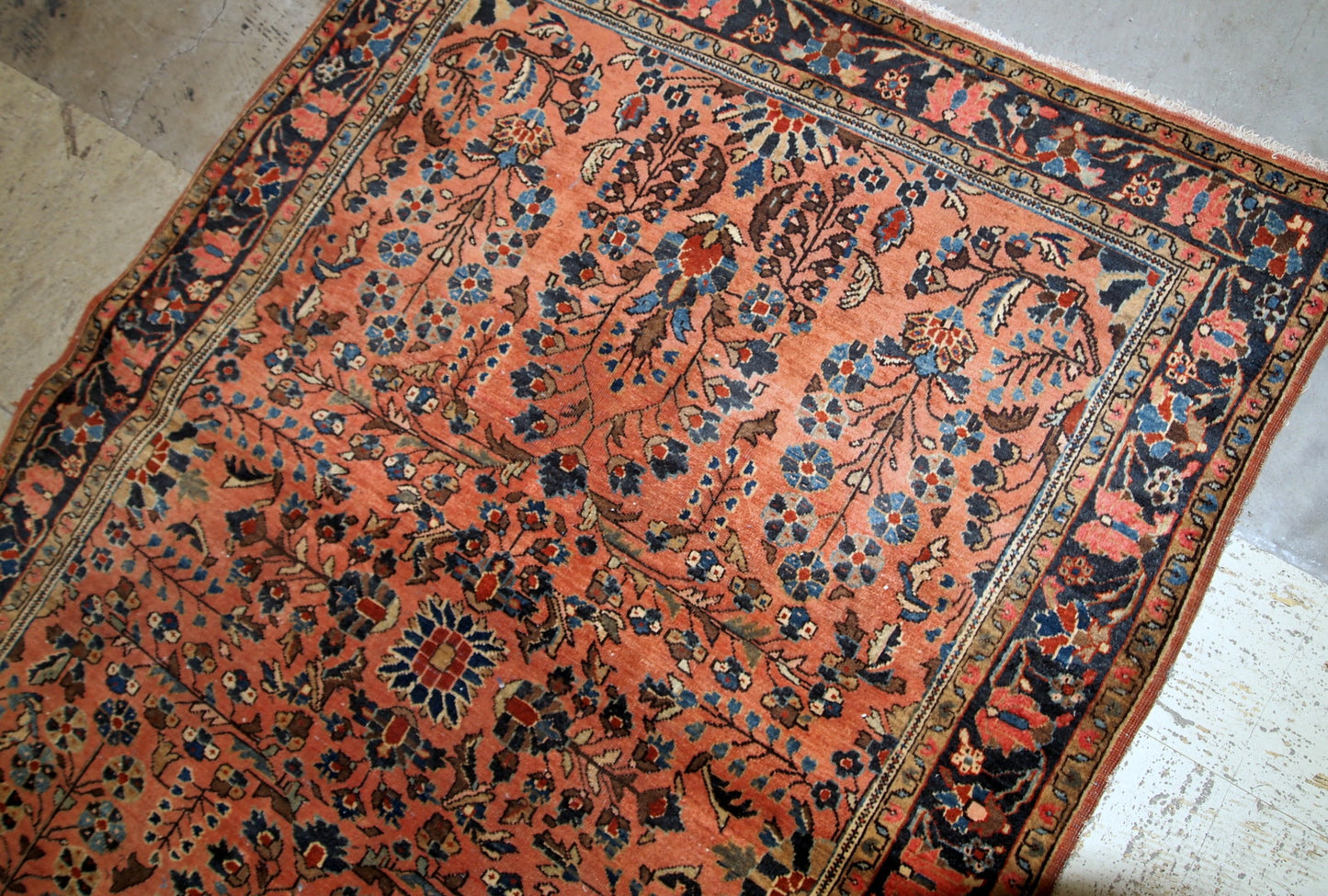 Handmade antique Sarouk rug in salmon shade. The rug is in original good condition from the beginning of 20th century.