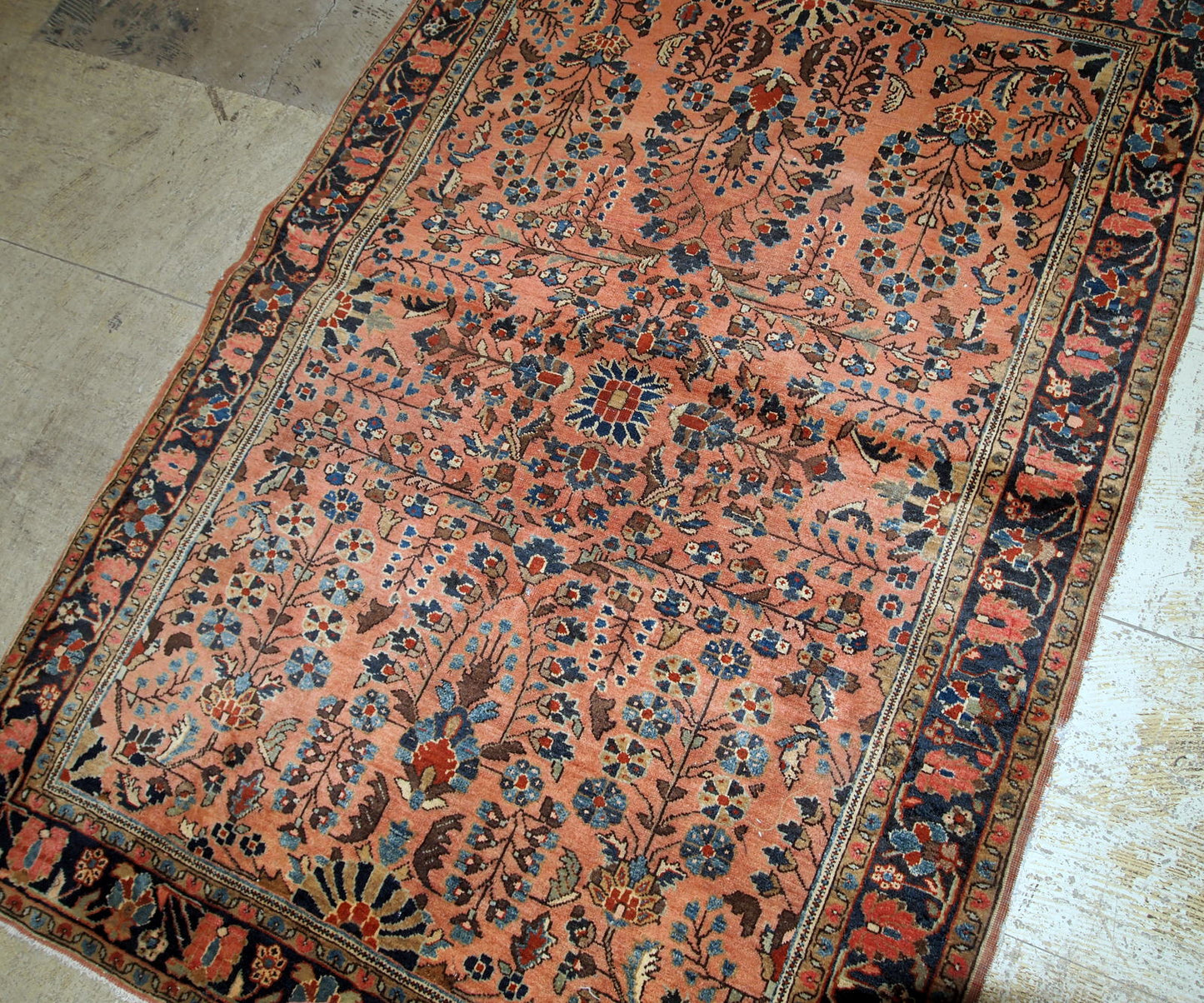 Handmade antique Sarouk rug in salmon shade. The rug is in original good condition from the beginning of 20th century.