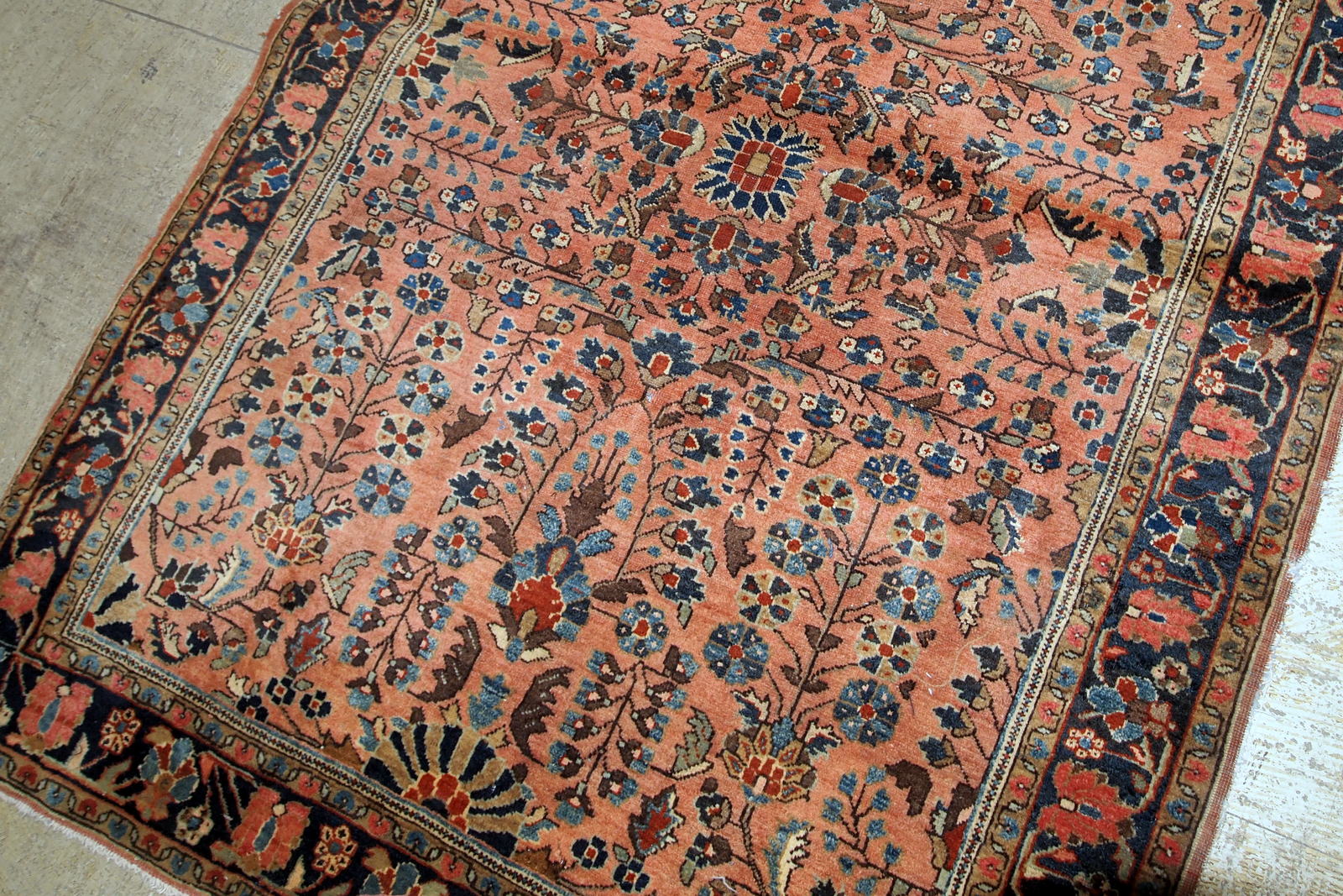 Handmade antique Sarouk rug in salmon shade. The rug is in original good condition from the beginning of 20th century.