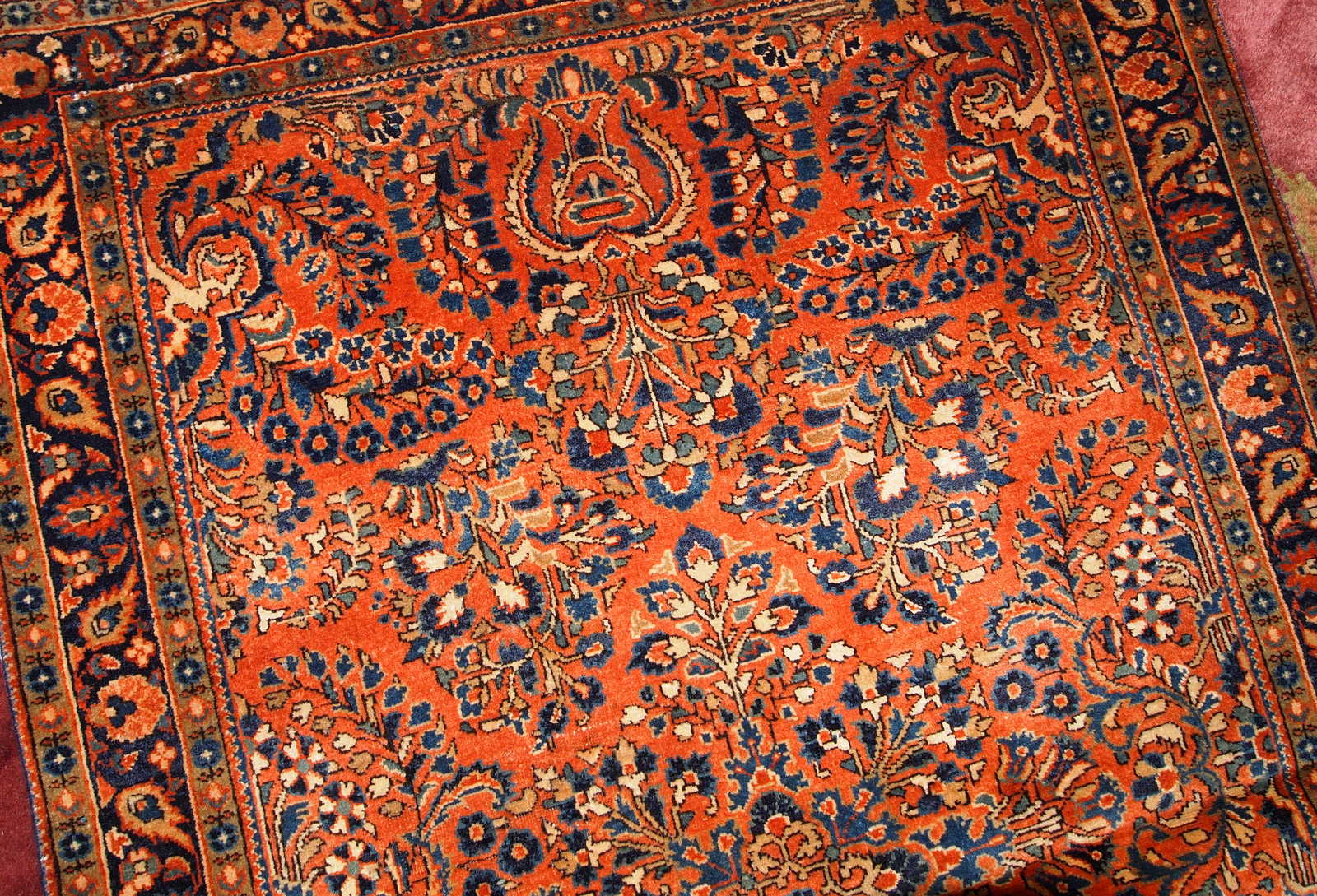 Hand made antique Persian Sarouk rug in red wool. The rug is in original good condition from the beginning of 20th century.