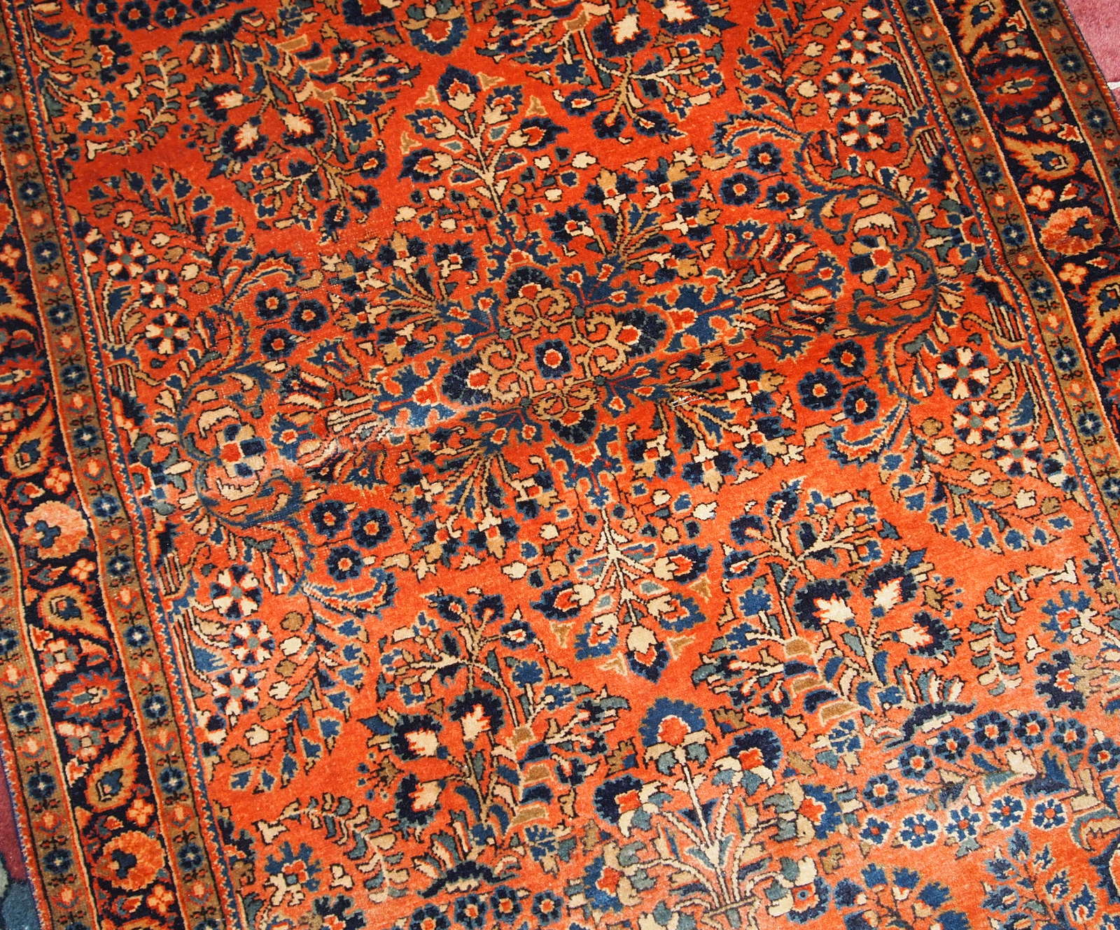 Hand made antique Persian Sarouk rug in red wool. The rug is in original good condition from the beginning of 20th century.