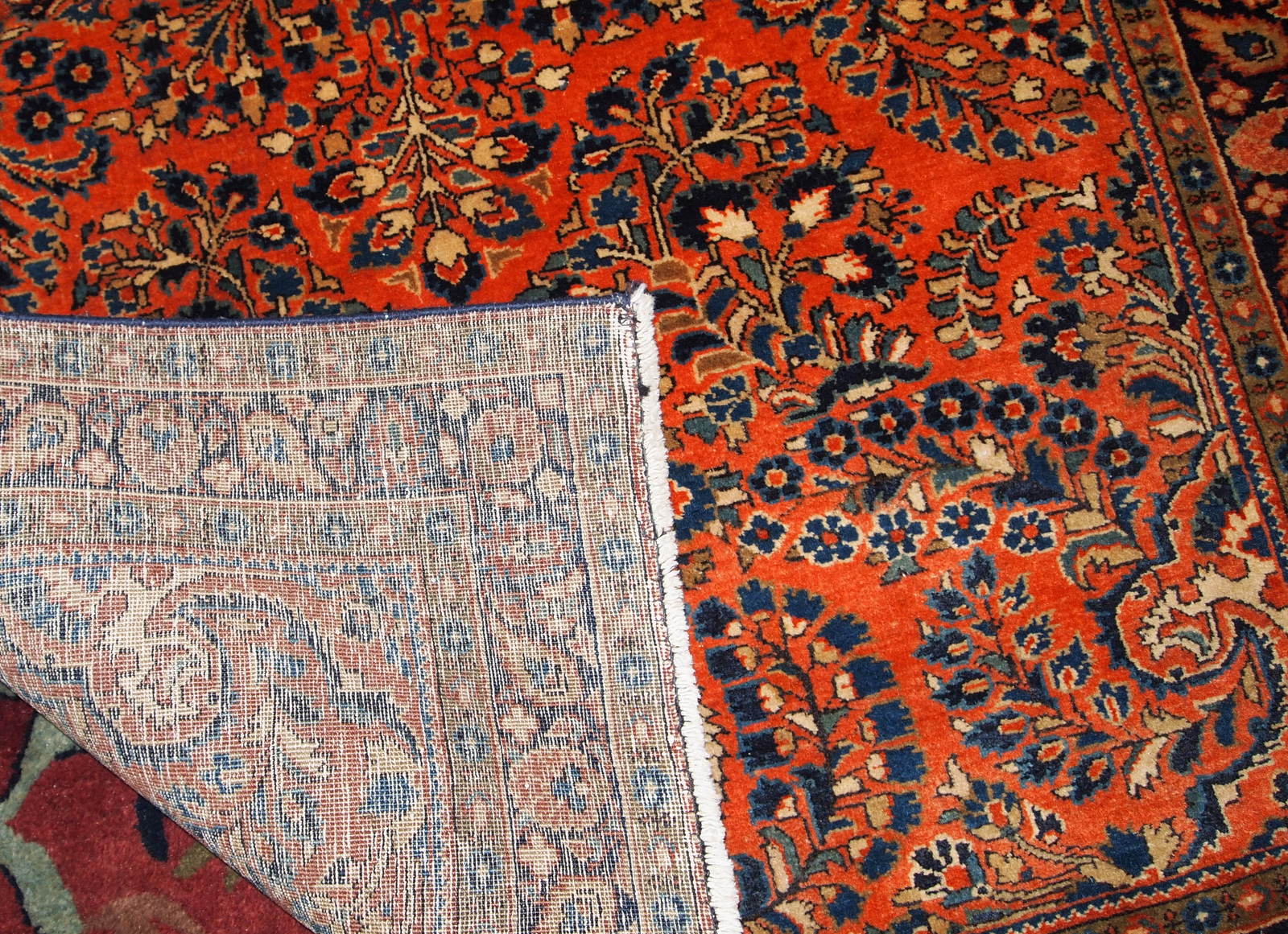 Hand made antique Persian Sarouk rug in red wool. The rug is in original good condition from the beginning of 20th century.