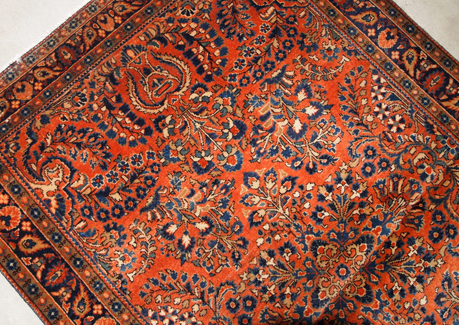 Hand made antique Persian Sarouk rug in red wool. The rug is in original good condition from the beginning of 20th century.