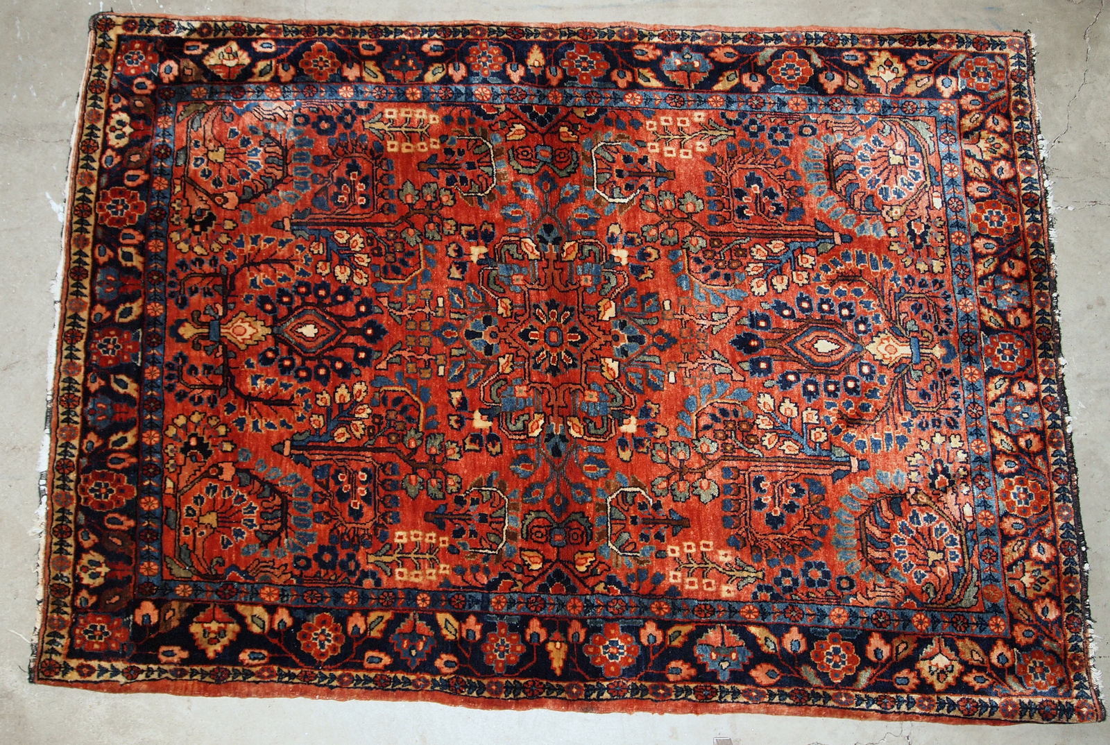 This antique Persian Sarouk rug made in the beginning of 20th century in red wool. The rug is in original good condition.