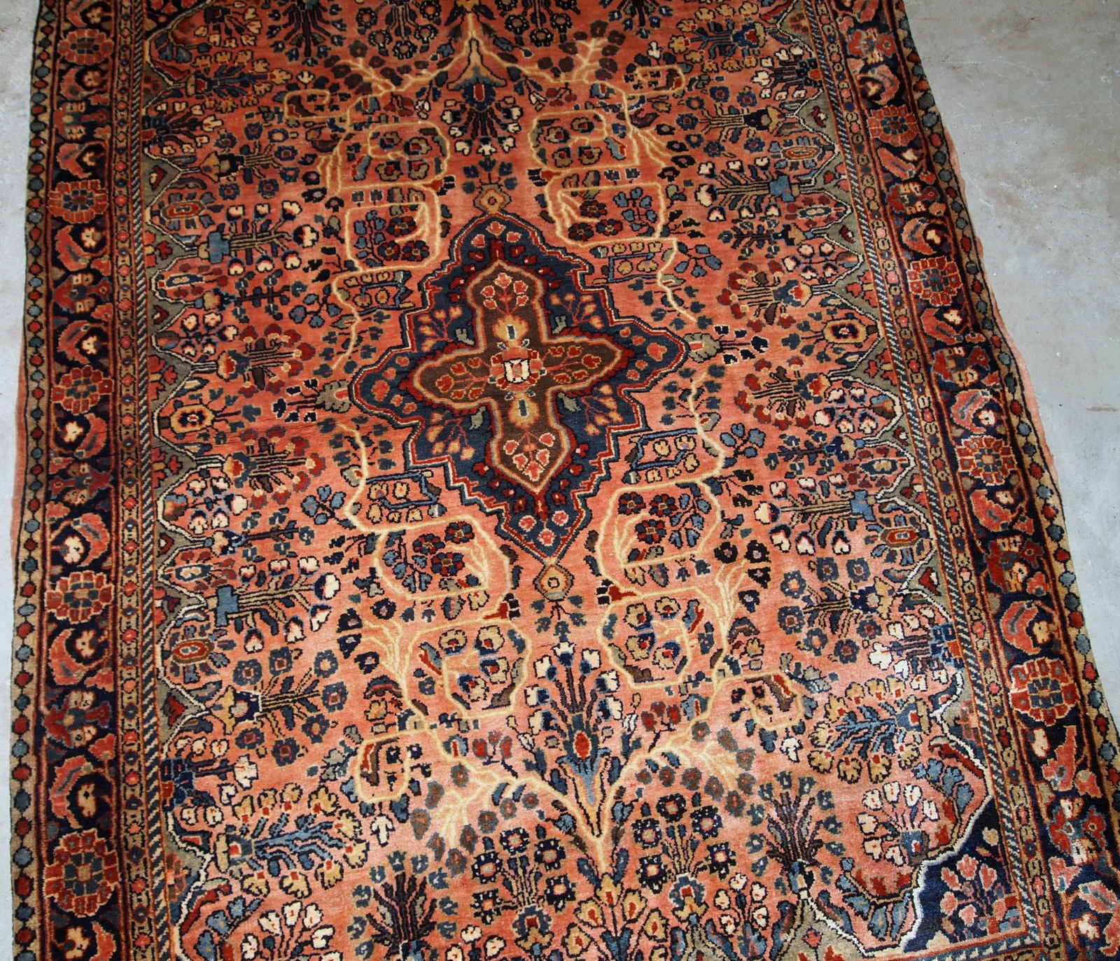 Antique hand made Persian Sarouk rug in peach shades. The rug is from the beginning of 20th century in original good condition.