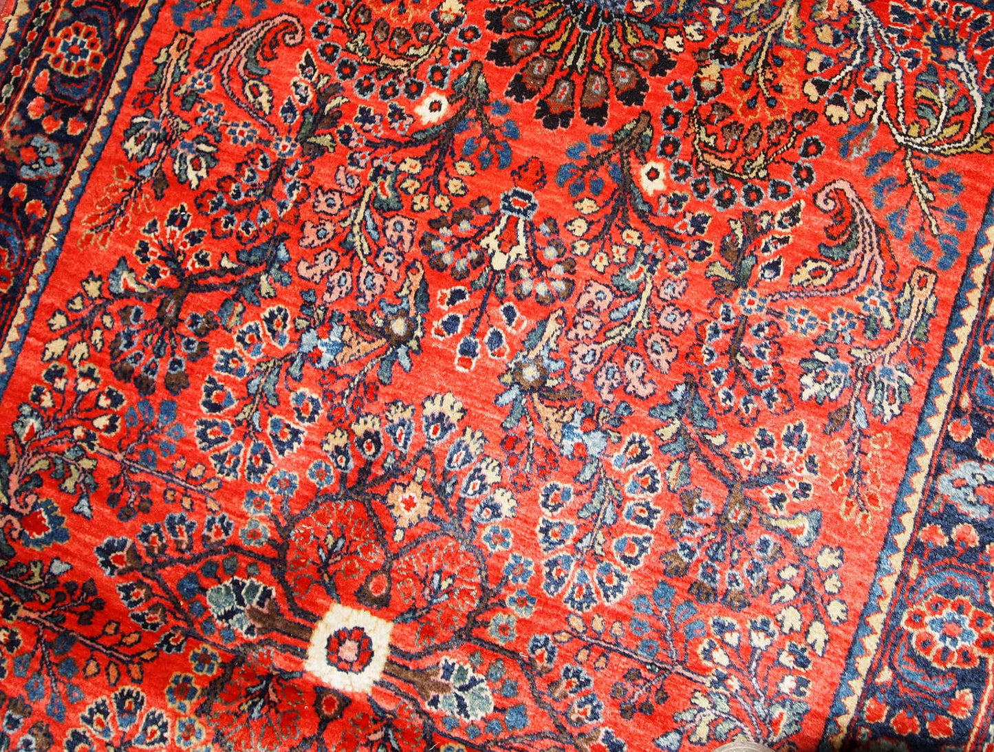 Antique handmade Persian Sarouk rug in red color. The rug is in original good condition from the beginning of 20th century.
