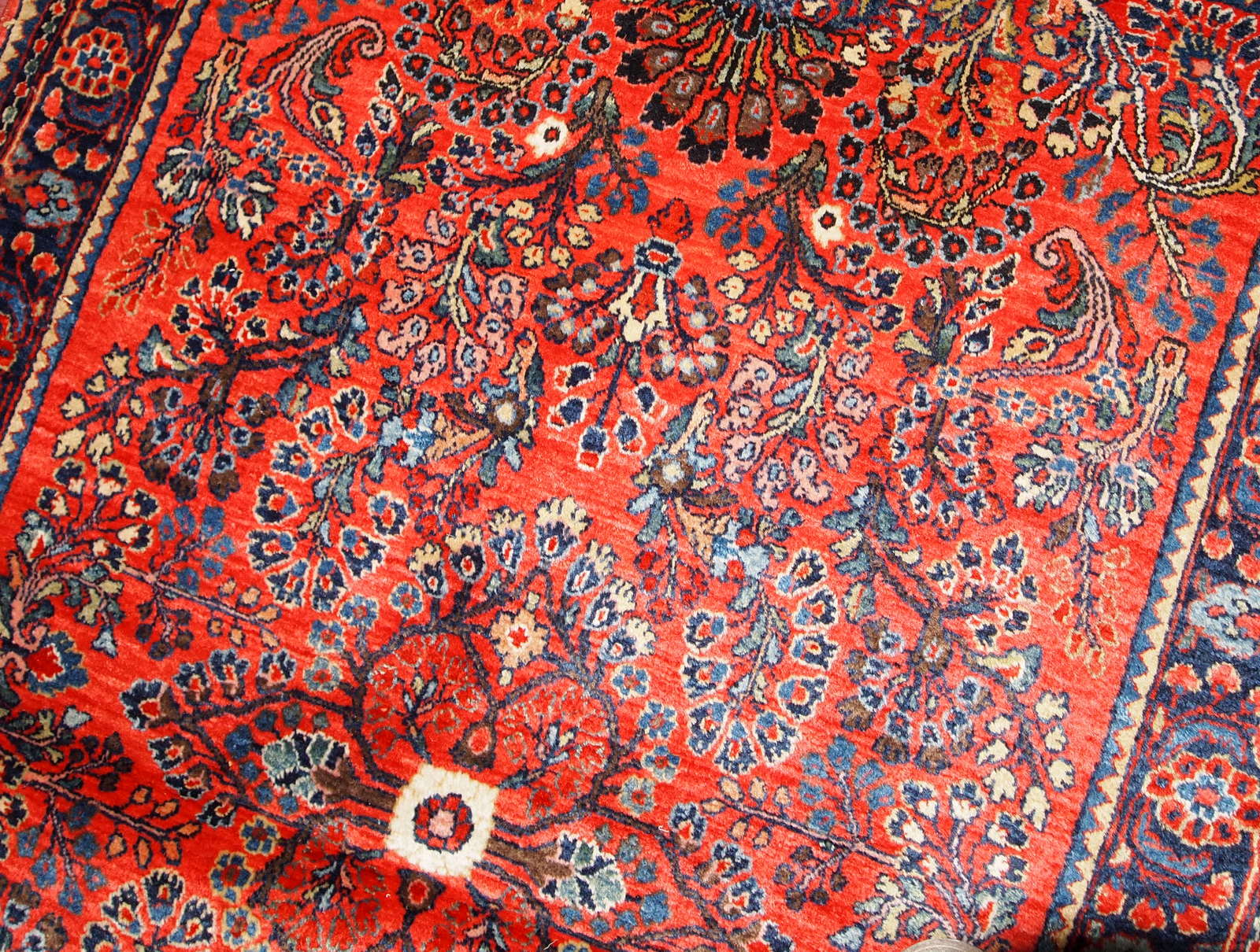 Antique handmade Persian Sarouk rug in red color. The rug is in original good condition from the beginning of 20th century.