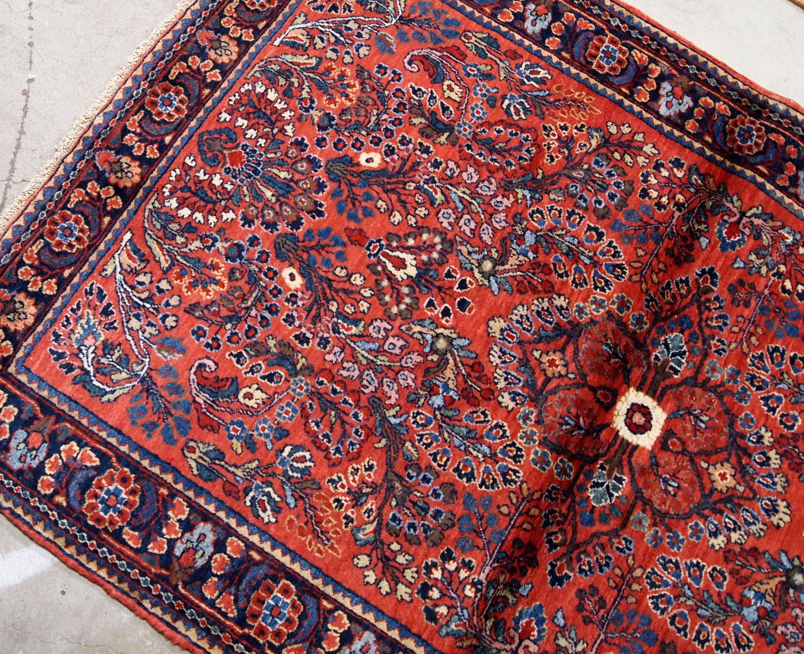 Antique handmade Persian Sarouk rug in red color. The rug is in original good condition from the beginning of 20th century.