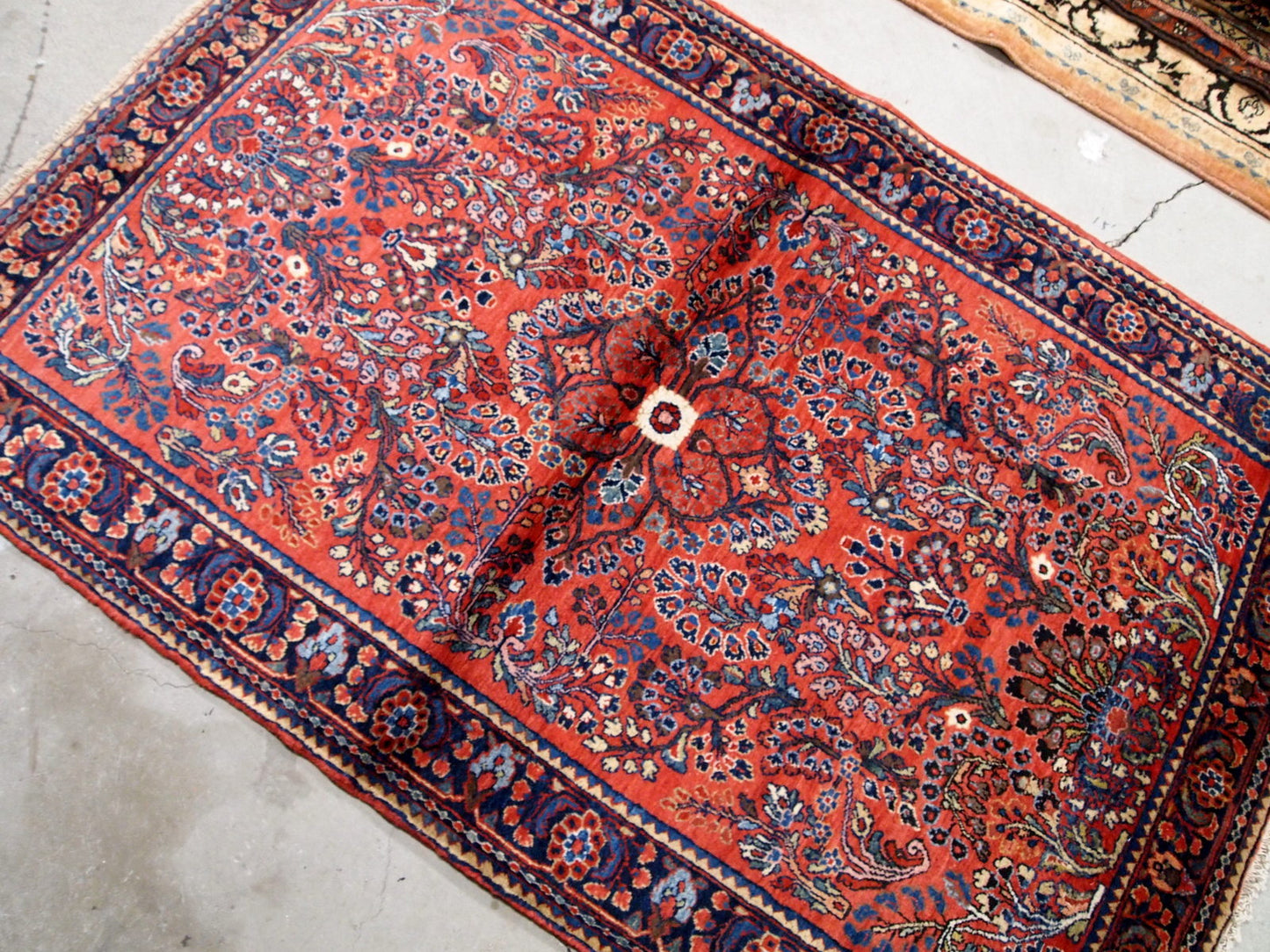 Antique handmade Persian Sarouk rug in red color. The rug is in original good condition from the beginning of 20th century.