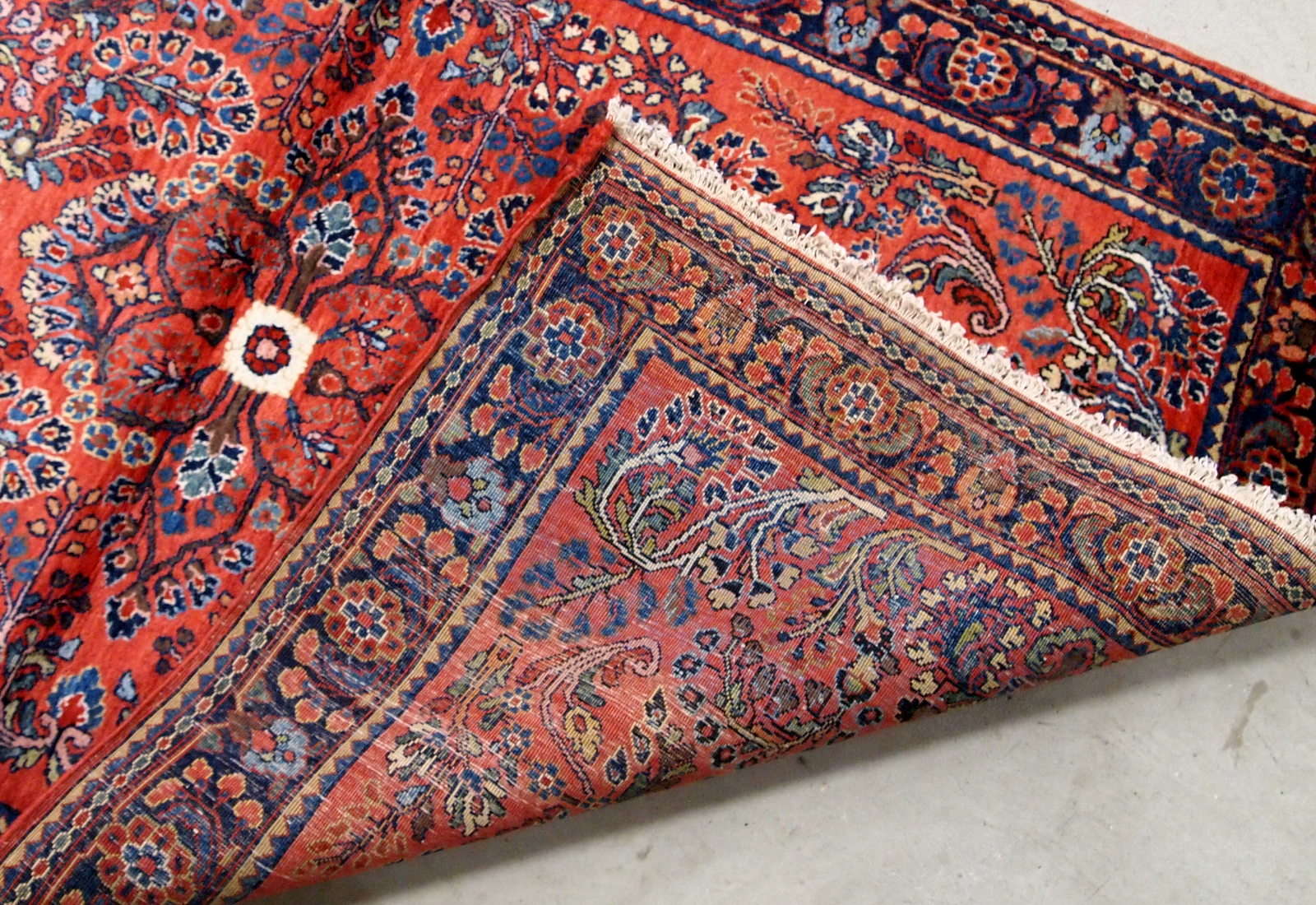 Antique handmade Persian Sarouk rug in red color. The rug is in original good condition from the beginning of 20th century.