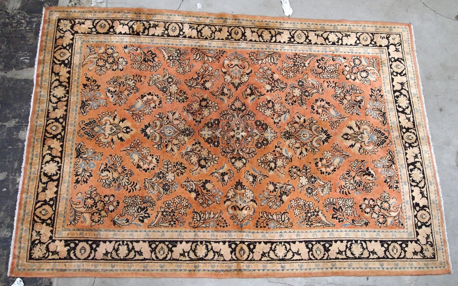 Antique hand made Persian Sarouk rug in salmon shade. The rug is from the beginning of 20th century in original good condition.