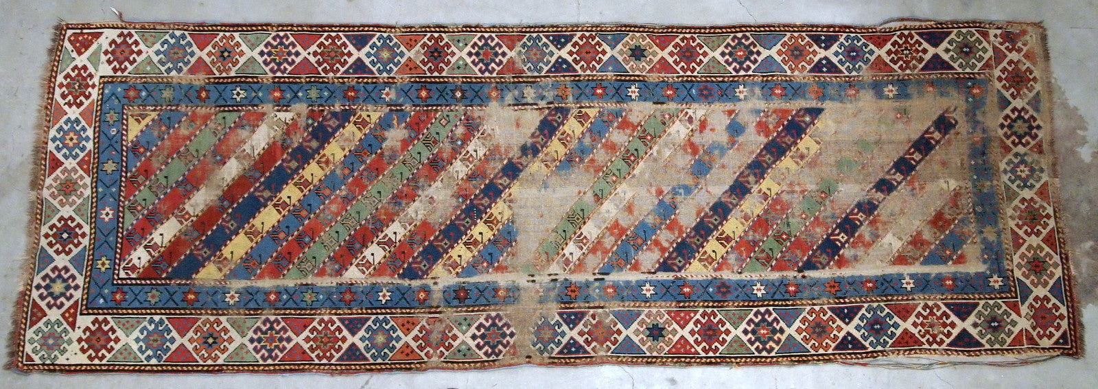Handmade antique Caucasian rug in distressed condition, from the end of 19th century. 