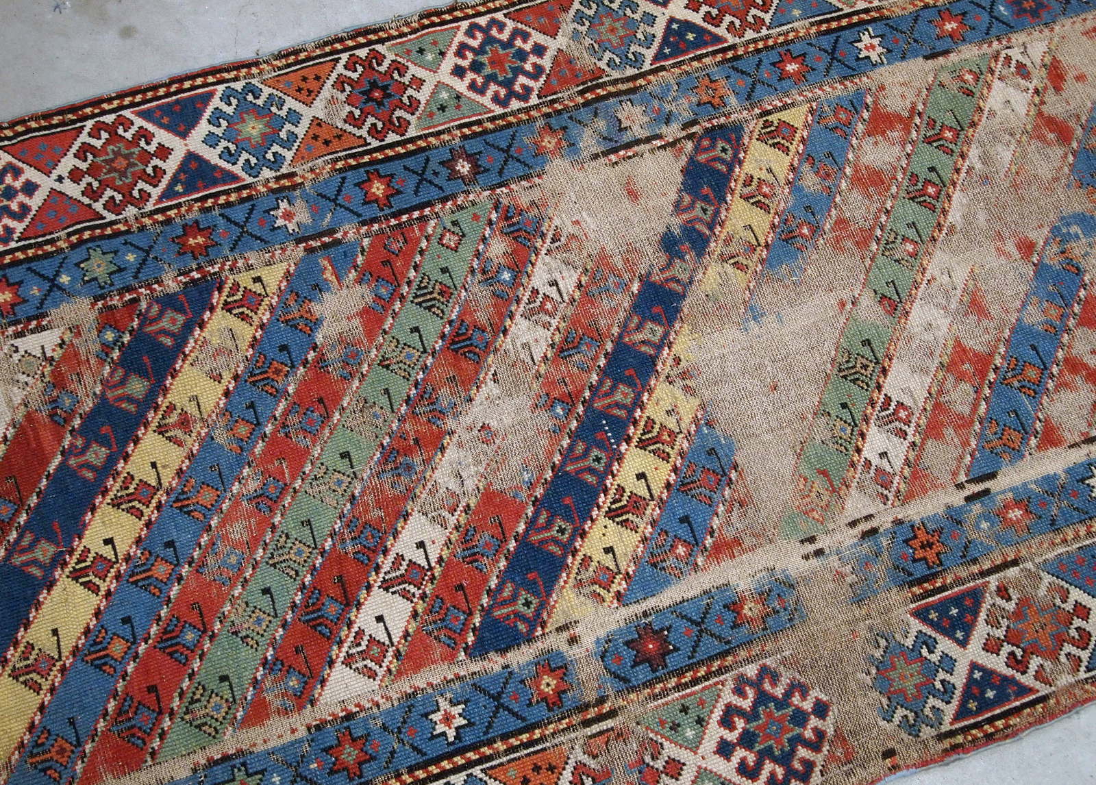 Handmade antique Caucasian rug in distressed condition, from the end of 19th century. 