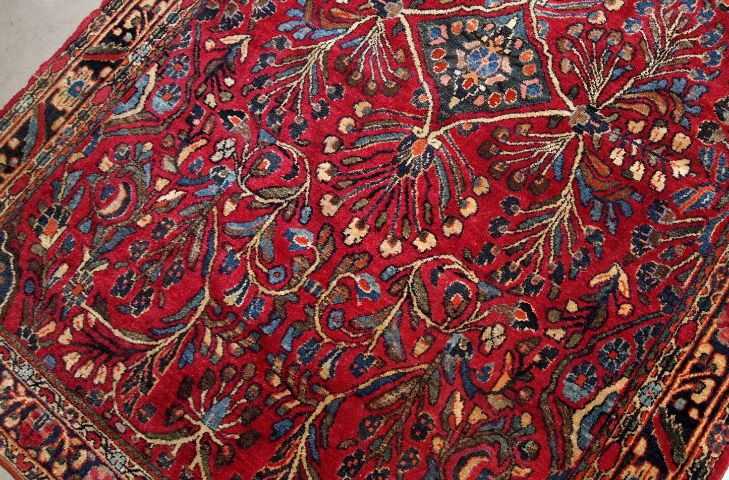 Handmade antique Sarouk rug in bright wool. It has been made in the beginning of 20th century in Middle East region.