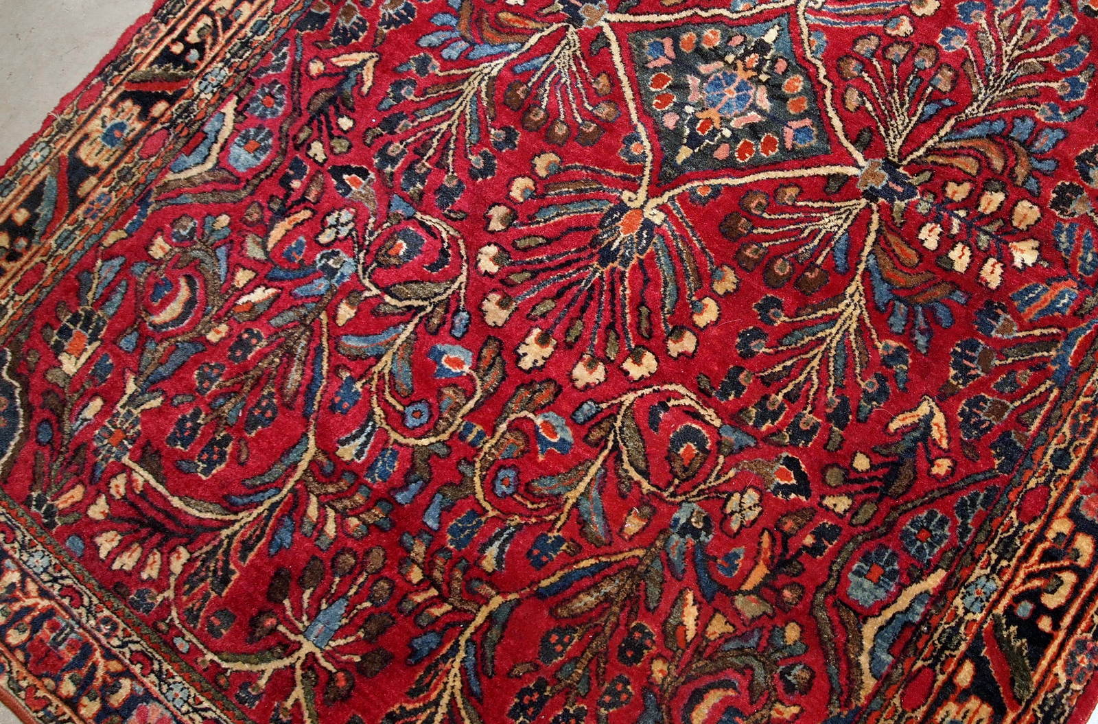 Handmade antique Sarouk rug in bright wool. It has been made in the beginning of 20th century in Middle East region.