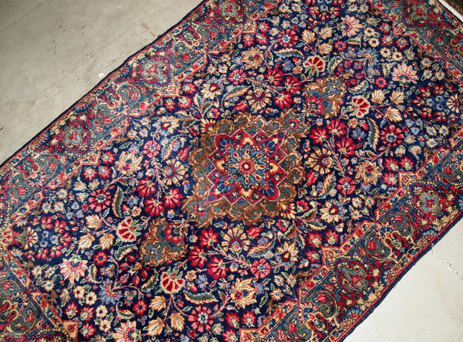 Handmade antique Kerman rug from the beginning of 20th century. The rug is in original good condition made in colorful shades and floral design.