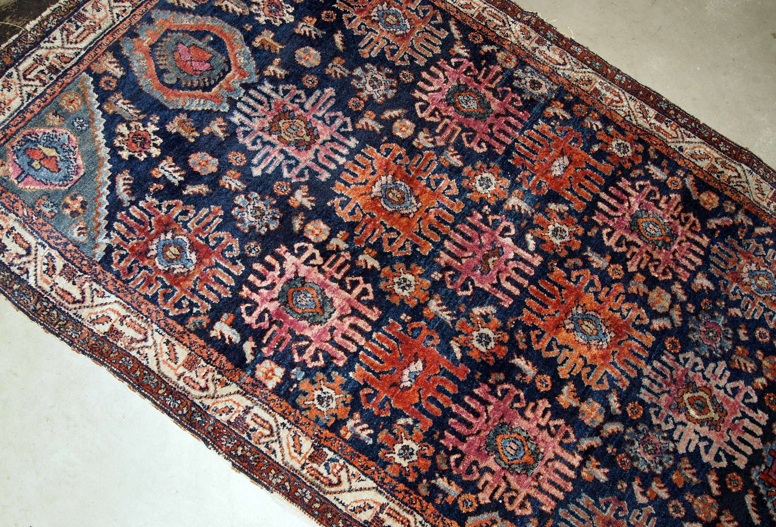 Handmade antique Malayer rug from the beginning of 20th century. The rug is in original good condition, has all-over design on navy blue background.