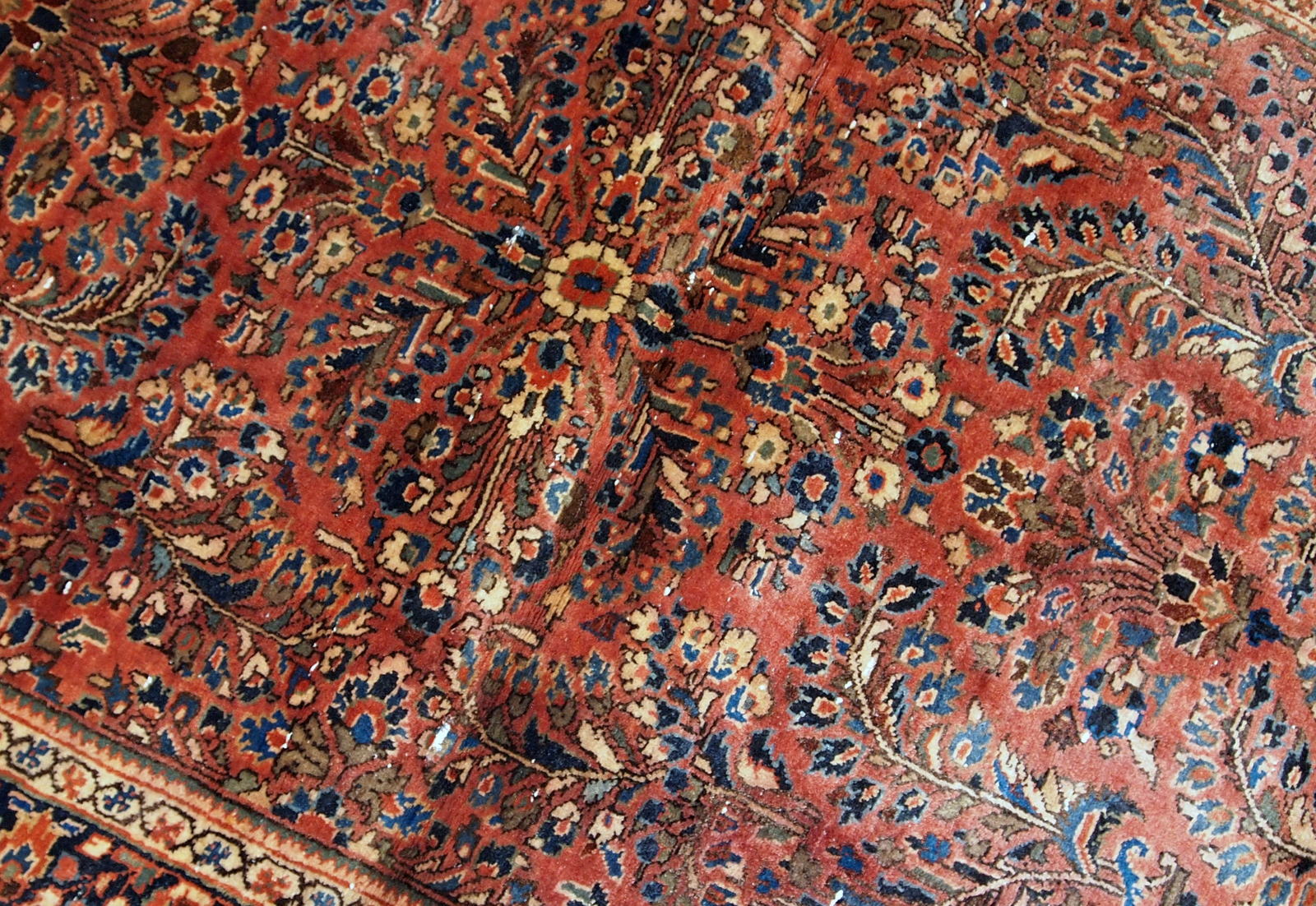 Hand-weaved antique Sarouk rug from the beginning of 20th century. The rug is in original good condition, made in classic floral design.