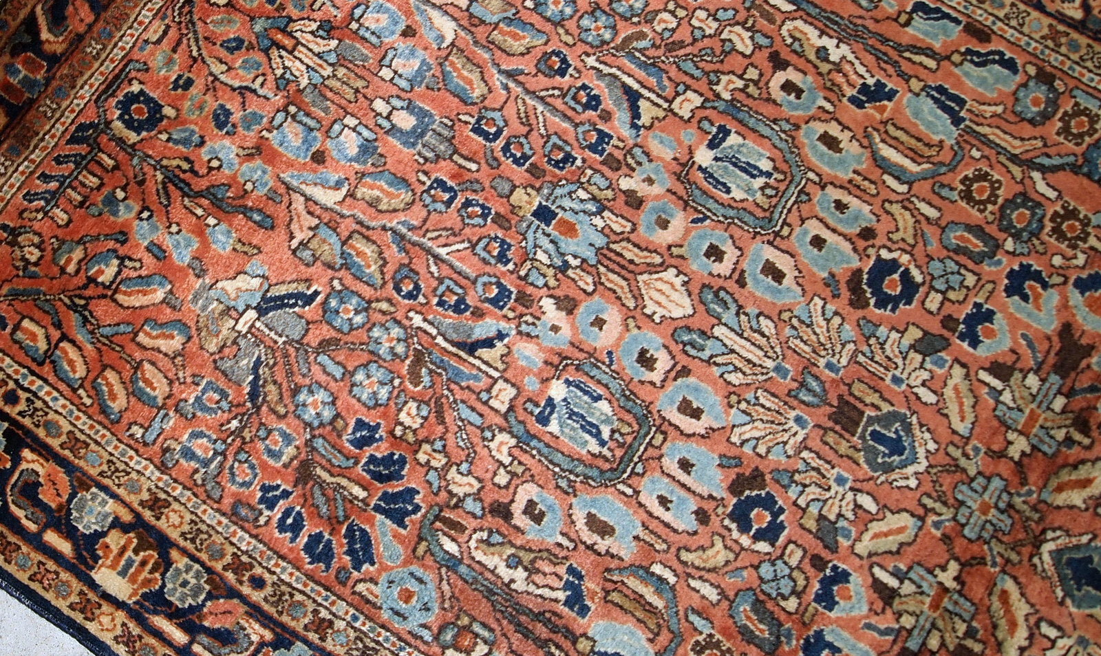 Hand-weaved antique Sarouk rug from the beginning of 20th century. The rug is in original good condition, made in classic floral design in red and sky blue shades.