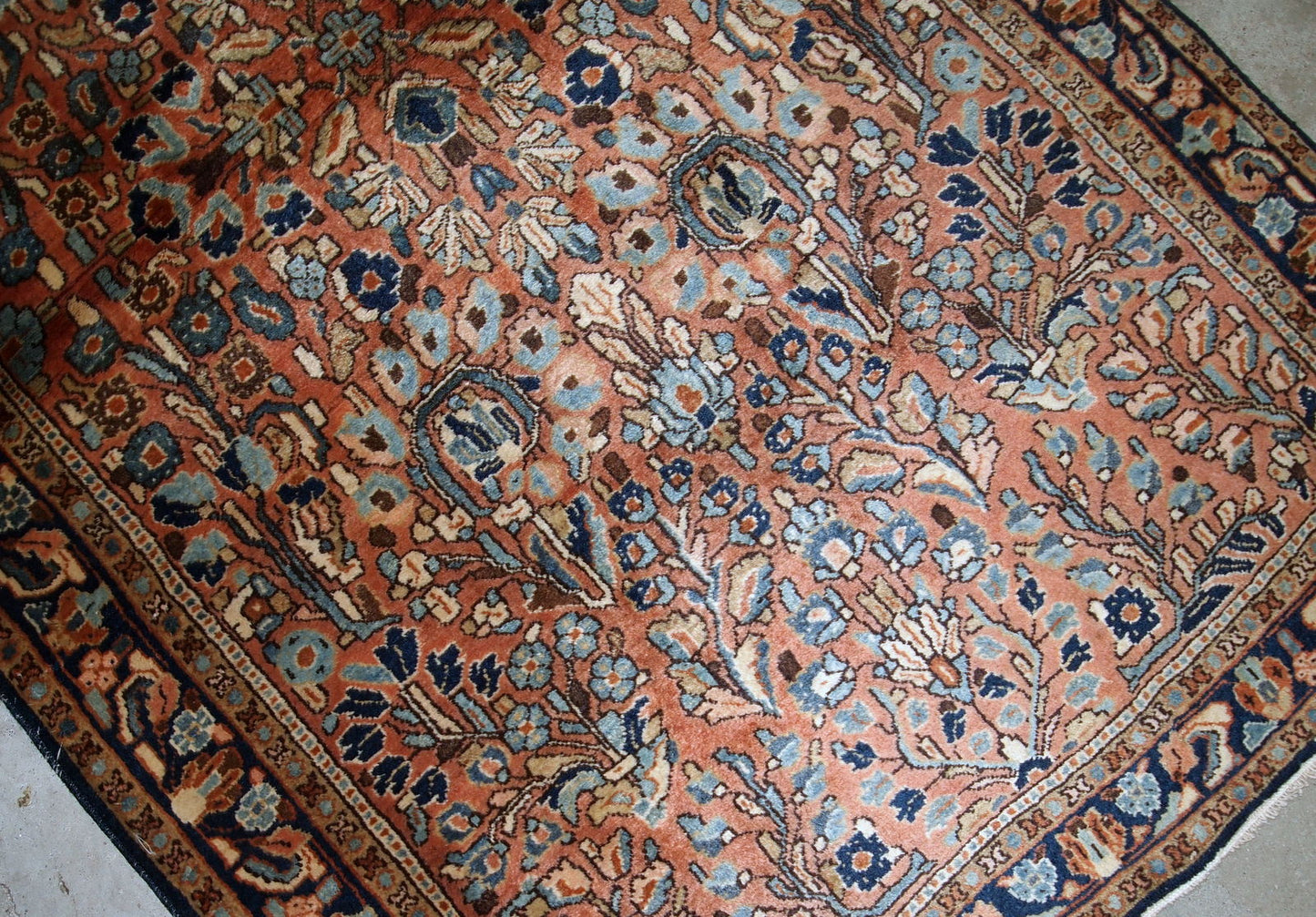 Hand-weaved antique Sarouk rug from the beginning of 20th century. The rug is in original good condition, made in classic floral design in red and sky blue shades.