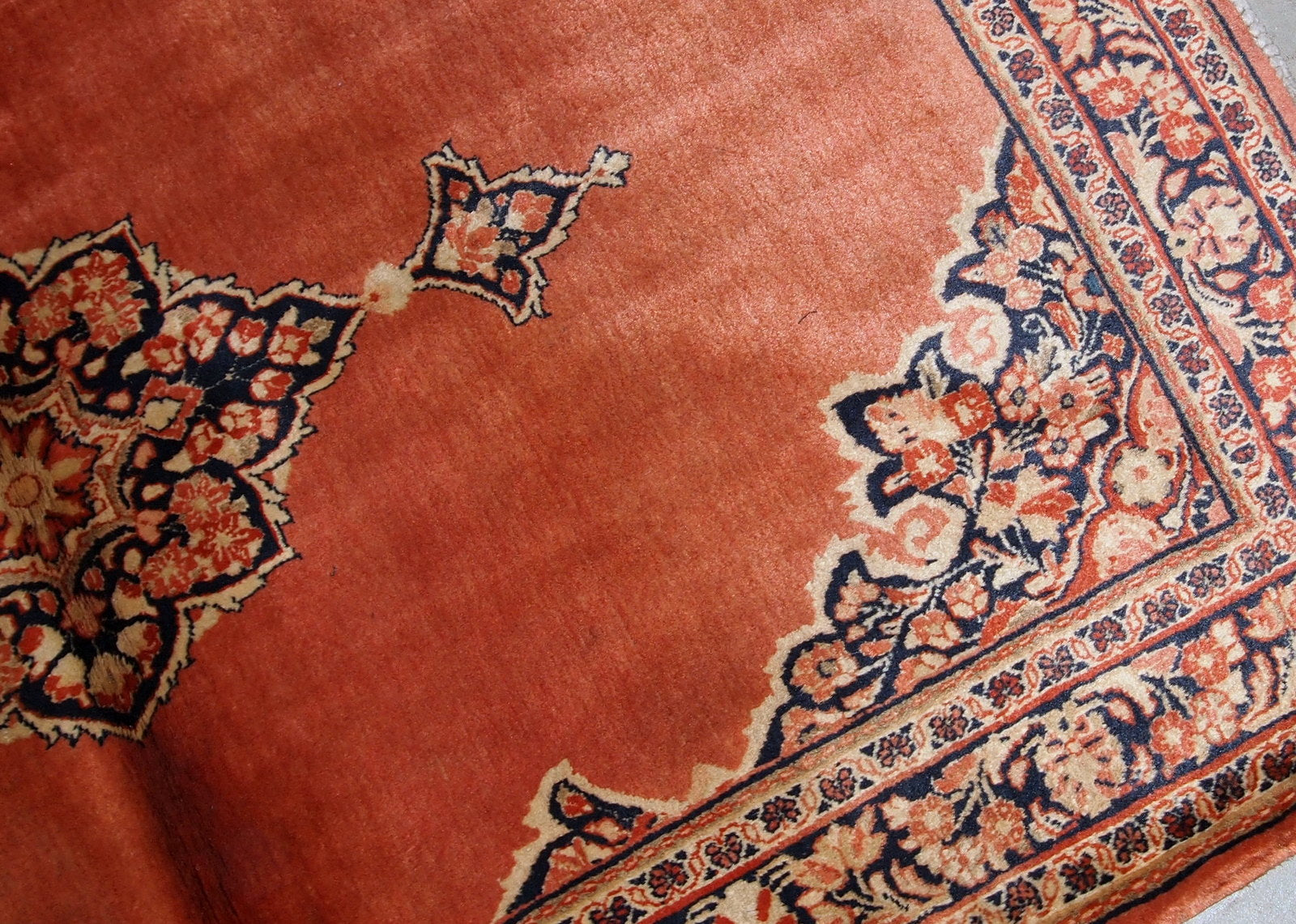 Hand-weaved antique Sarouk rug from the beginning of 20th century. The rug is in original good condition, made in traditional design from the shiny wool.
