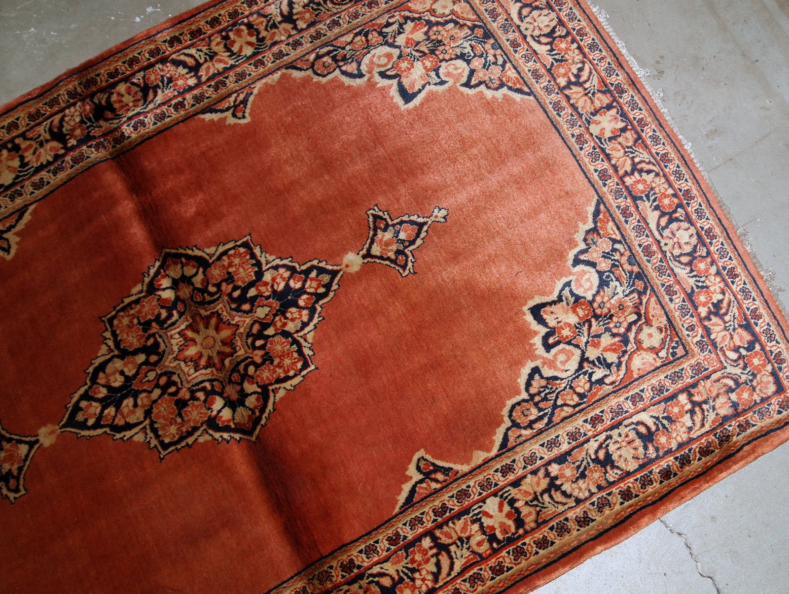 Hand-weaved antique Sarouk rug from the beginning of 20th century. The rug is in original good condition, made in traditional design from the shiny wool.