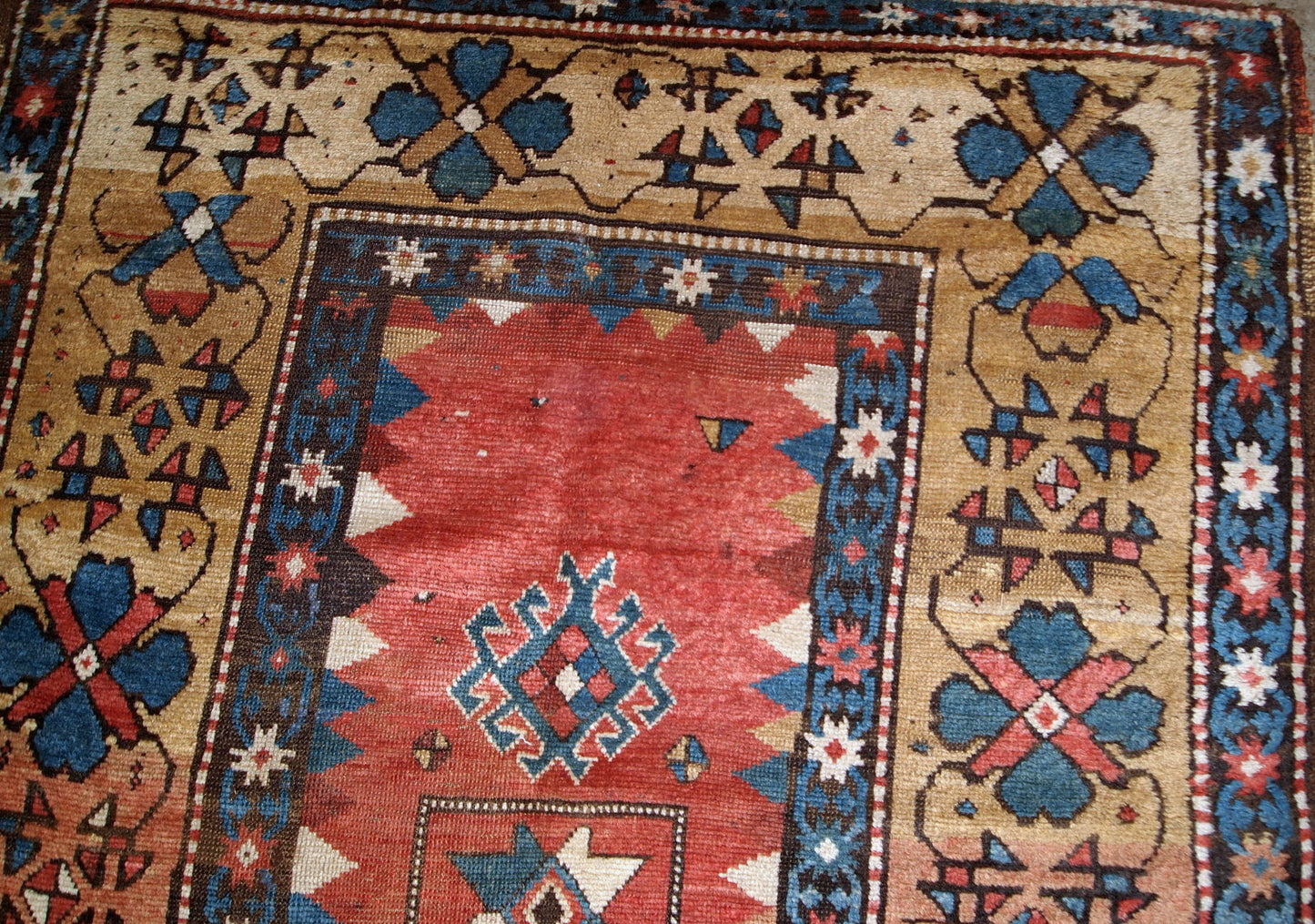 Handmade antique Caucasian Kazak rug in red and yellow shades. The rug is from the end of 19th century from Russia in original good condition.