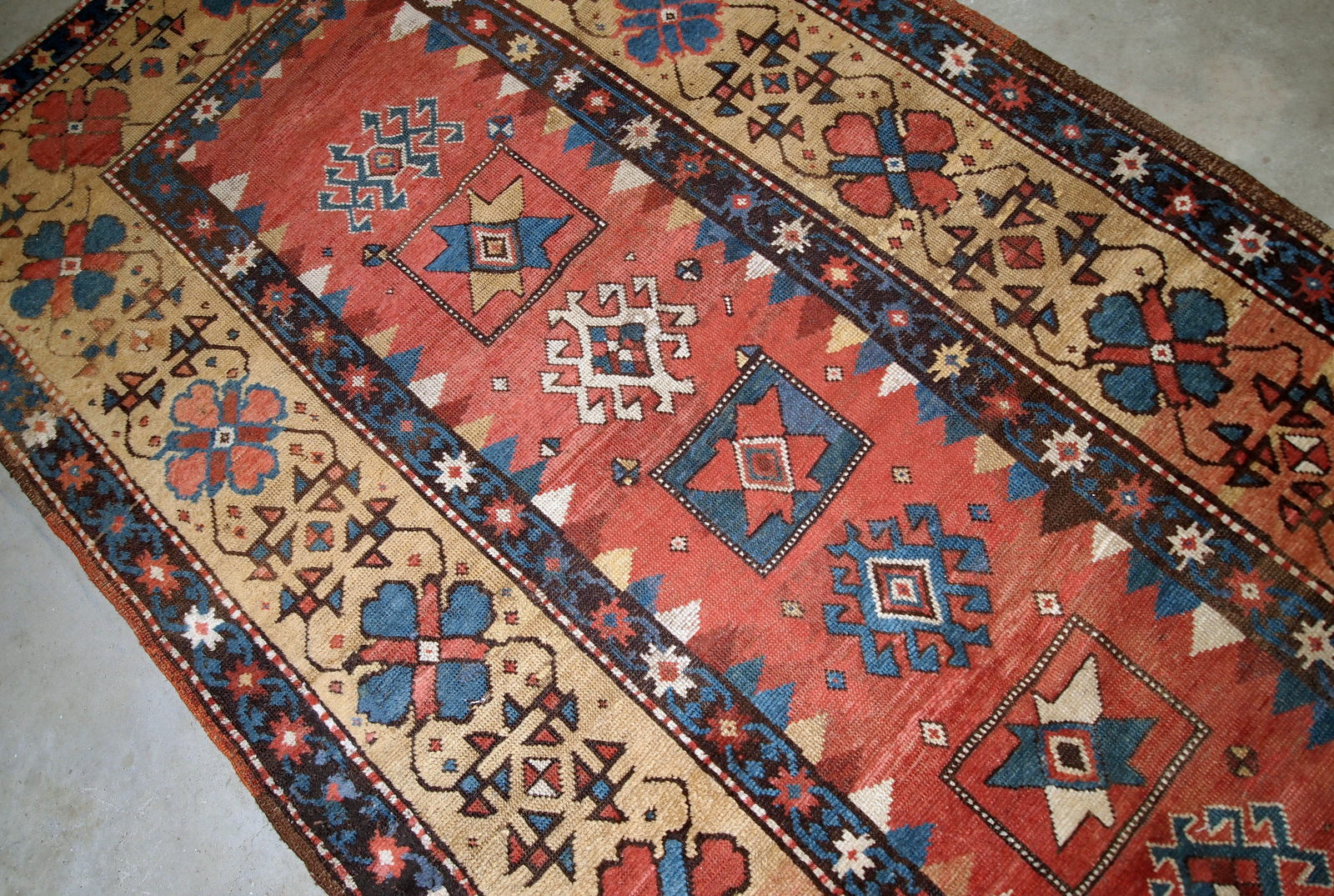 Handmade antique Caucasian Kazak rug in red and yellow shades. The rug is from the end of 19th century from Russia in original good condition.