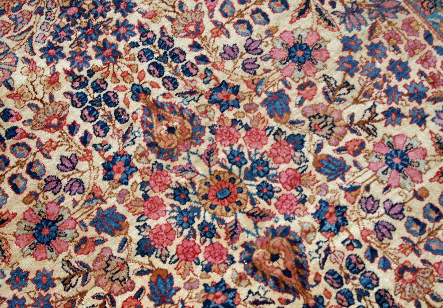 Hand-woven antique Kerman rug in original good condition, from the beginning of 20th century. The rug is in light shades and busy floral design.