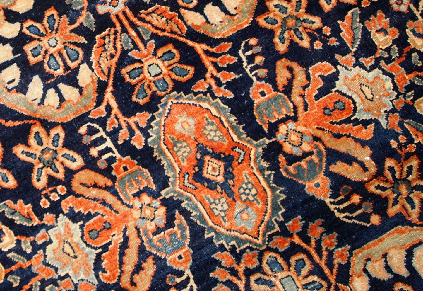 Antique hand-woven Sarouk rug in navy blue color. The rug is in original good condition, made in the beginning of 20th century.