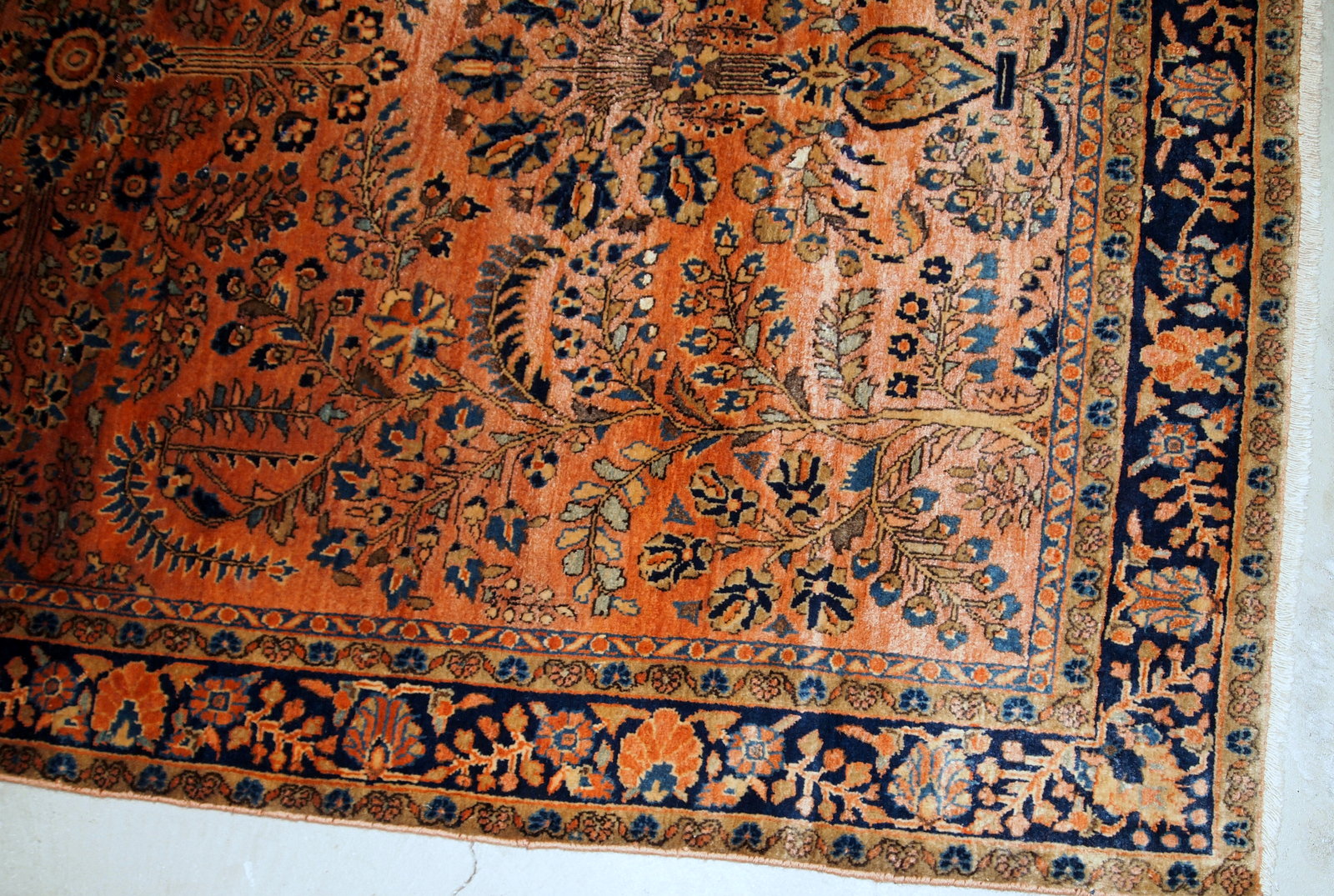 Handmade antique Sarouk rug in original good condition. The rug has been made in the beginning of 20th century in pale red wool.