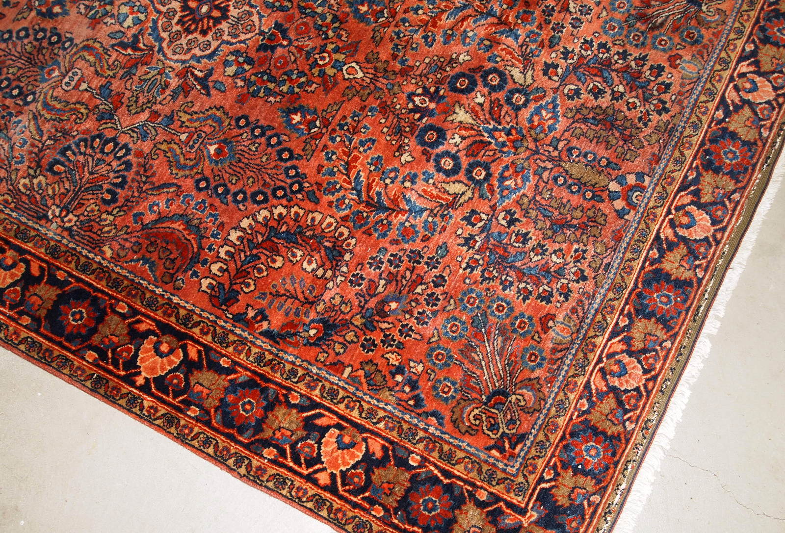 Handmade antique Sarouk rug in original good condition. The rug has been made in the beginning of 20th century in  red wool.