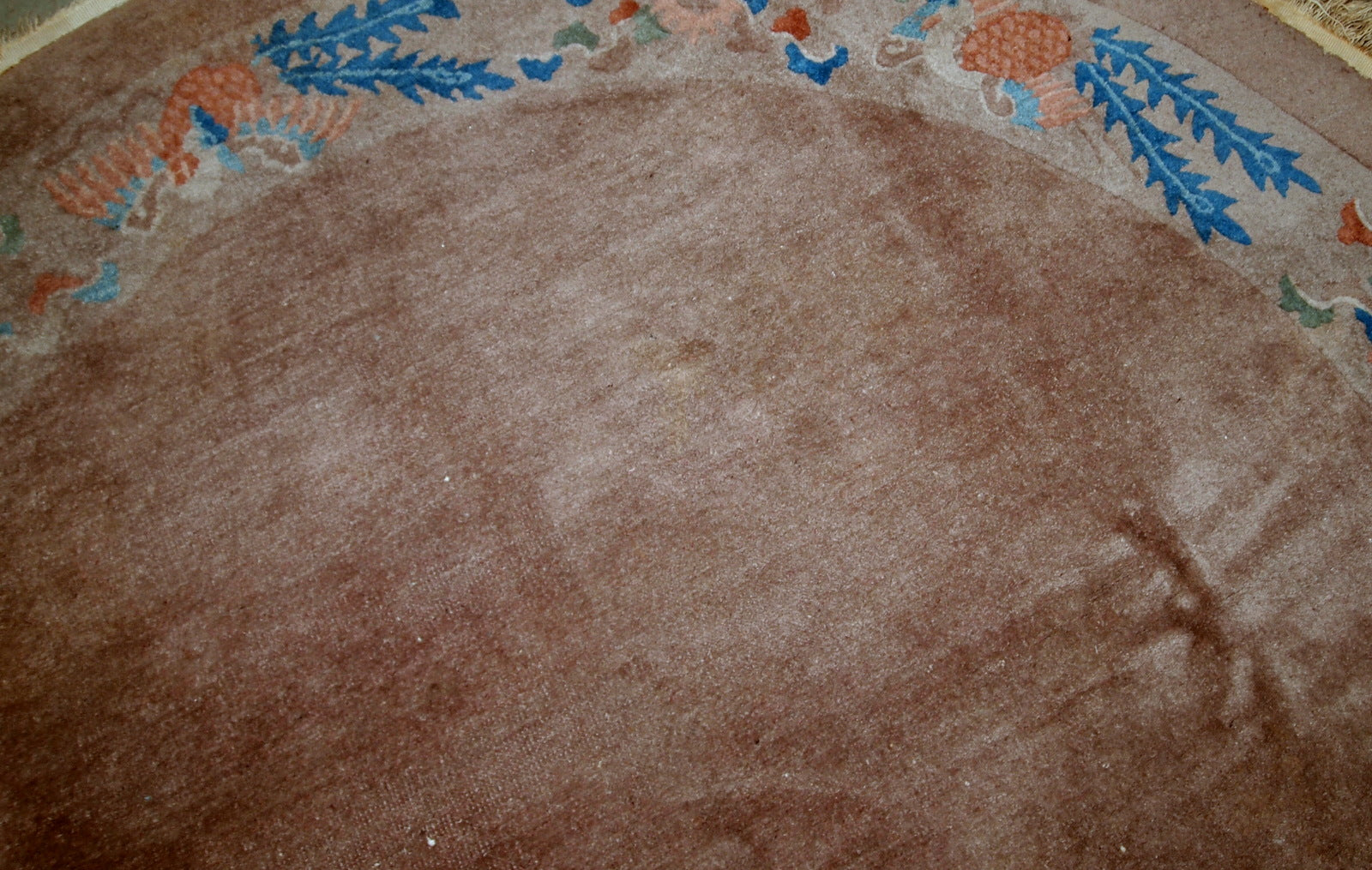 Handmade antique Art Deco Chinese rug in oval shape. The rug is from the beginning of 20th century in original condition, it has some low pile.