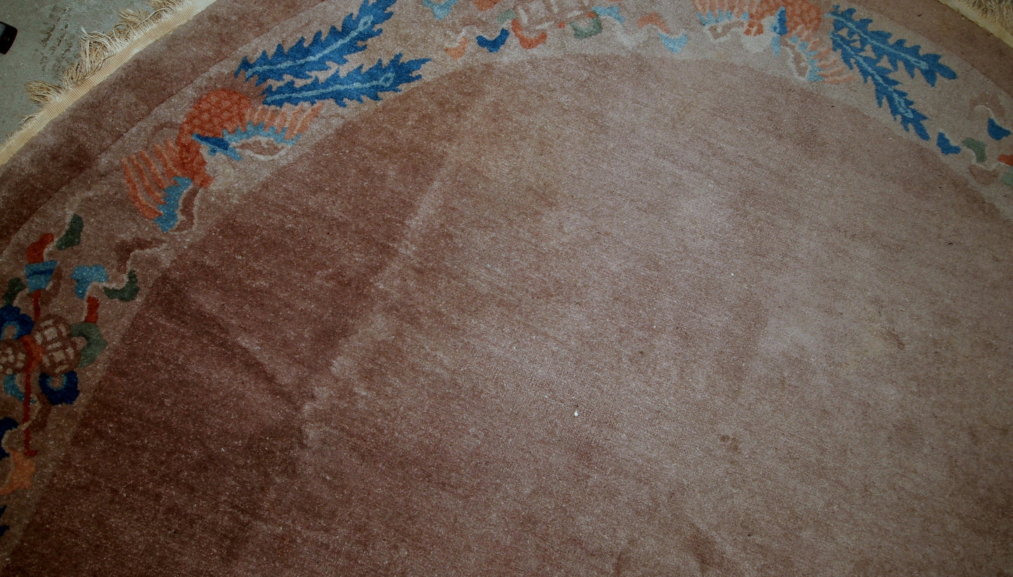 Handmade antique Art Deco Chinese rug in oval shape. The rug is from the beginning of 20th century in original condition, it has some low pile.