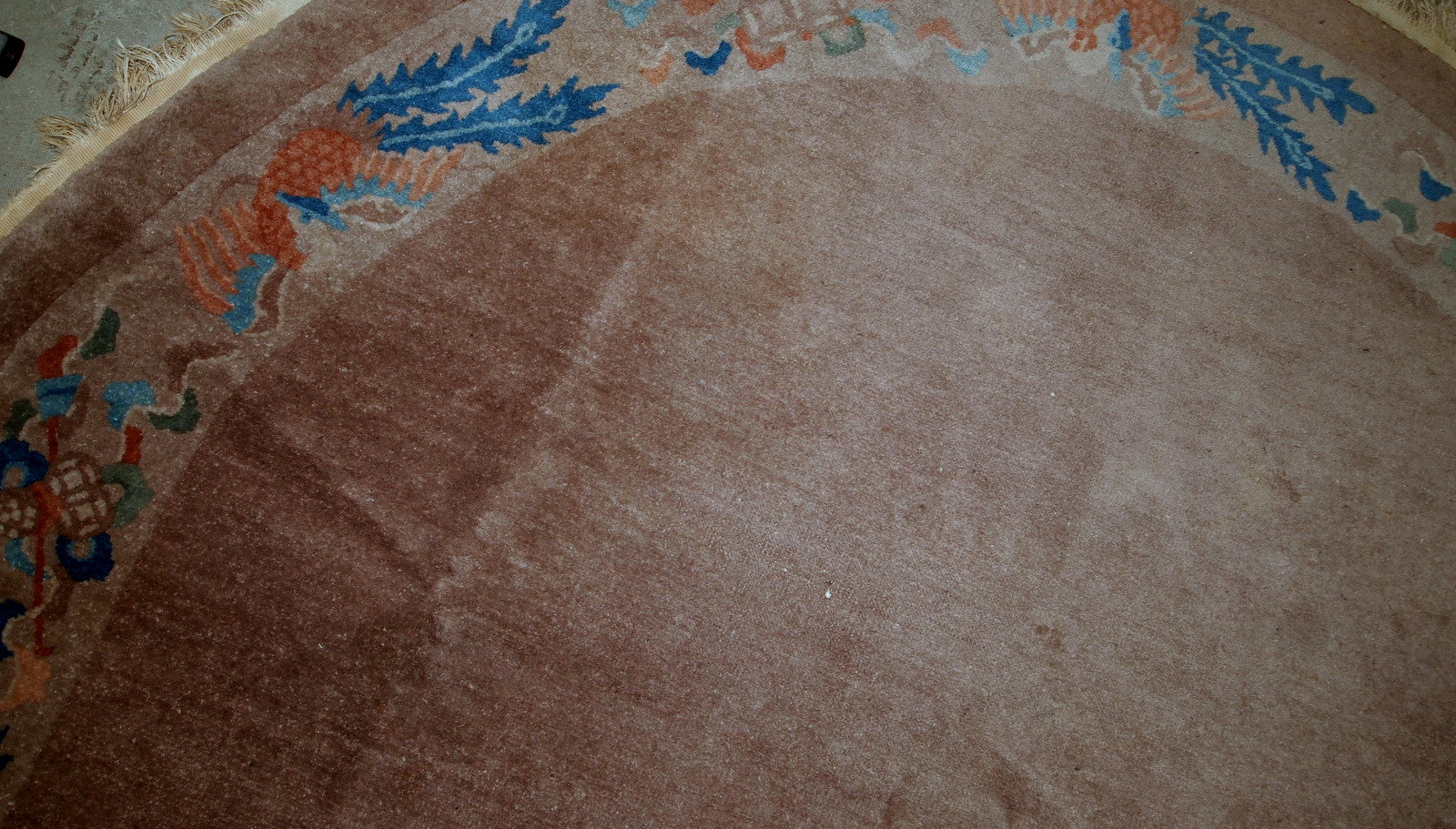 Handmade antique Art Deco Chinese rug in oval shape. The rug is from the beginning of 20th century in original condition, it has some low pile.