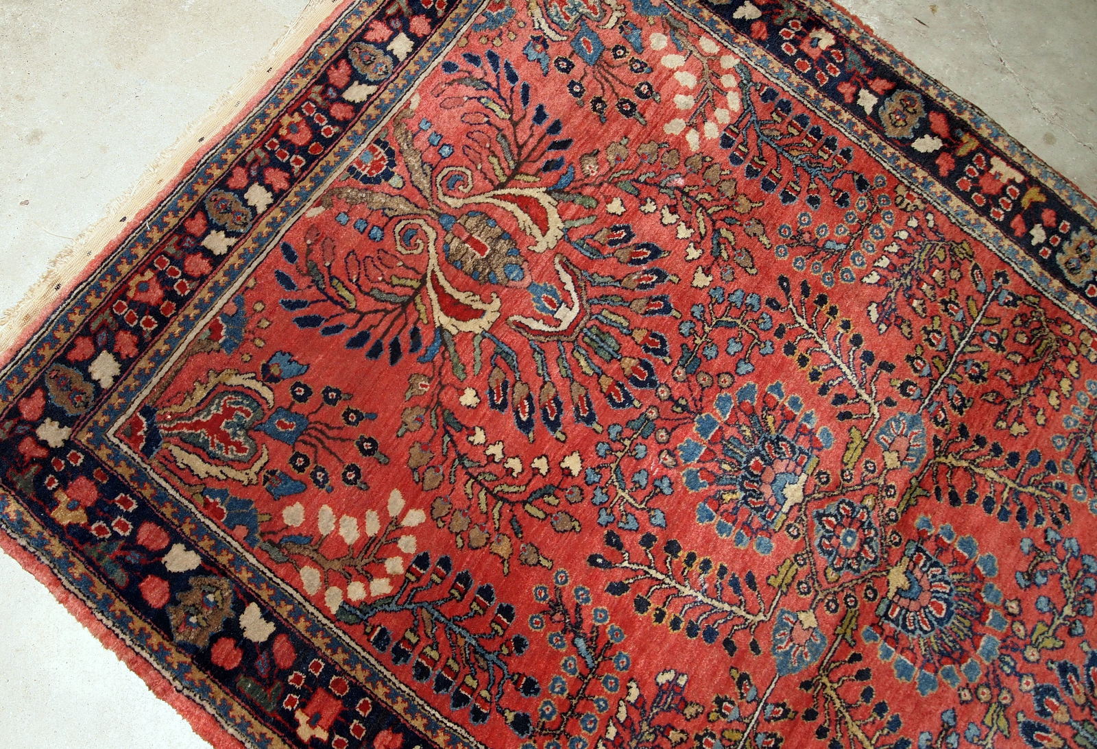 Handmade antique Sarouk rug in red color. The rug is from the beginning of 20th century in original good condition.