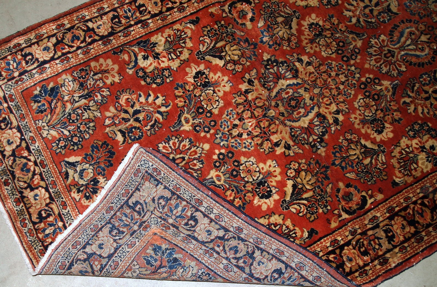 Handmade antique Persian Sarouk rug in original good condition. The rug is from the beginning of 20th century made in traditional floral design.