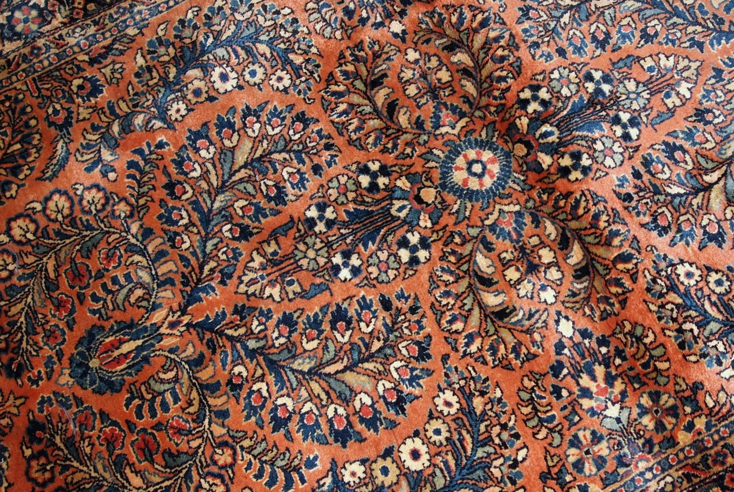 Handmade antique Persian Sarouk rug in original condition, it as some age wear on one corner. The rug is from the beginning of 20th century made in traditional floral design.