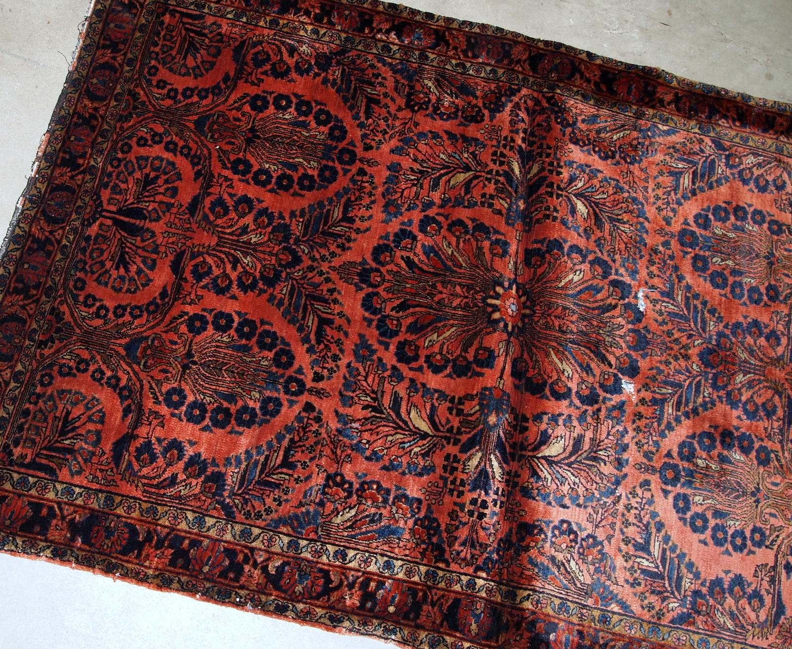Handmade antique Persian Sarouk rug in original good condition. The rug is from the beginning of 20th century made in bright red shade.