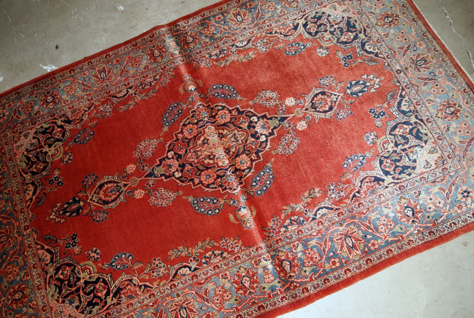 Handmade antique Persian Sarouk rug in original good condition. The rug is from the beginning of 20th century made in bright red wool. 